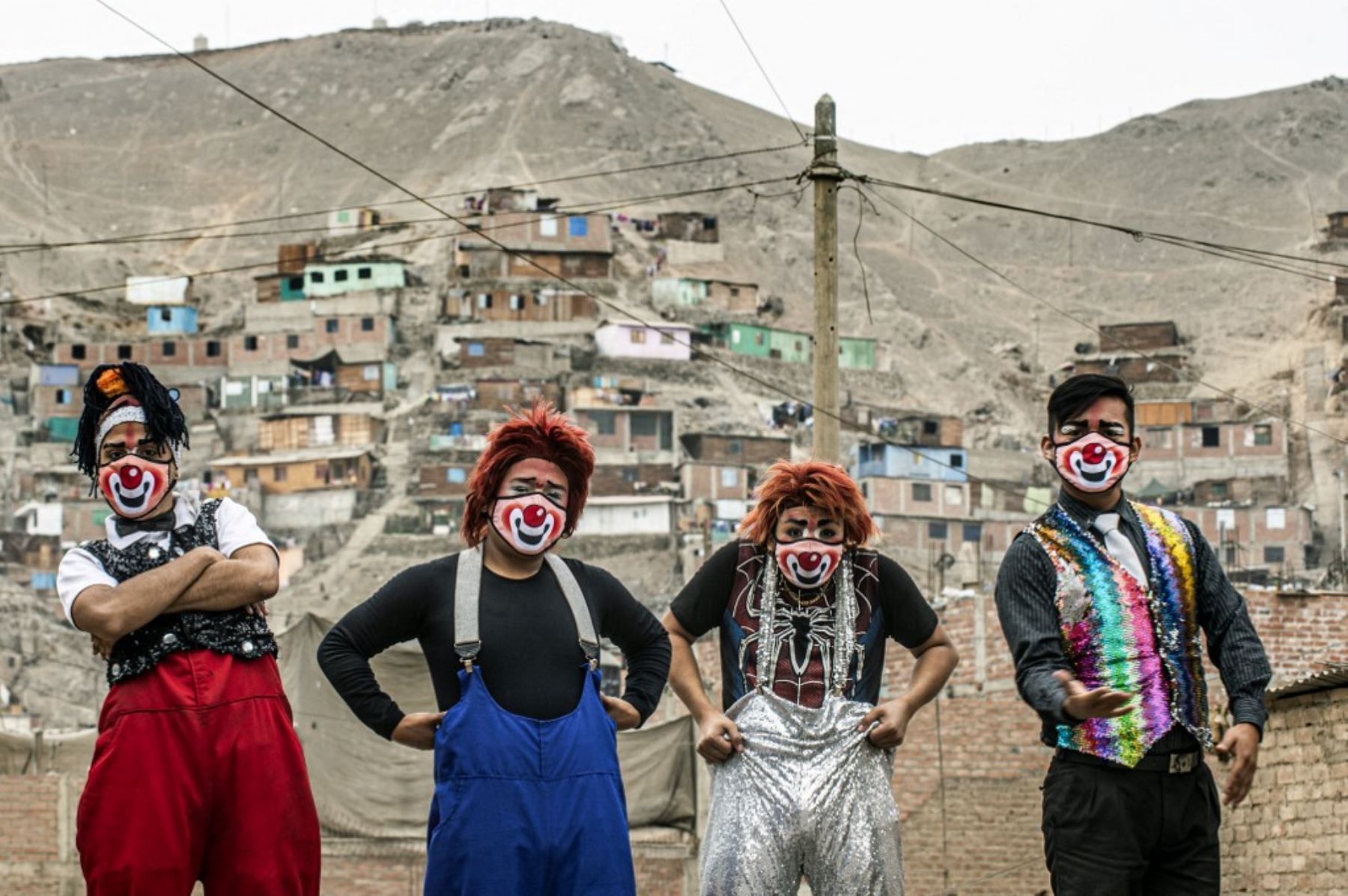 Los payasos con máscaras se presentan en el distrito de Puente Piedra, en las afueras del norte de Lima, durante la pandemia covid-19. - Debido a la pandemia de coronavirus, los circos en Perú permanecen cerrados, lo que lleva a este grupo de payasos que viajan en su circo mototaxi a actuar en las calles de Lima. 

Foto: AFP