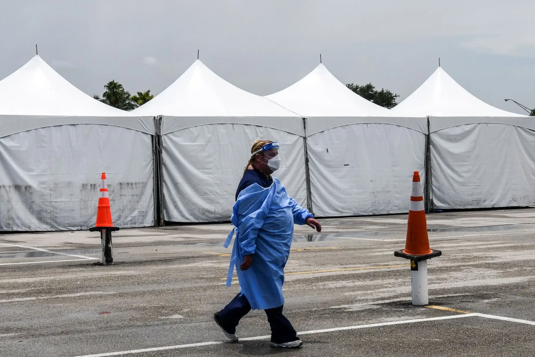 Un miembro del personal médico usa un equipo de protección personal (EPP), que incluye máscaras faciales y escudo, cerca del sitio de prueba rápida de antígeno coronavirus en el Hard Rock Stadium en Miami.
Foto: AFP