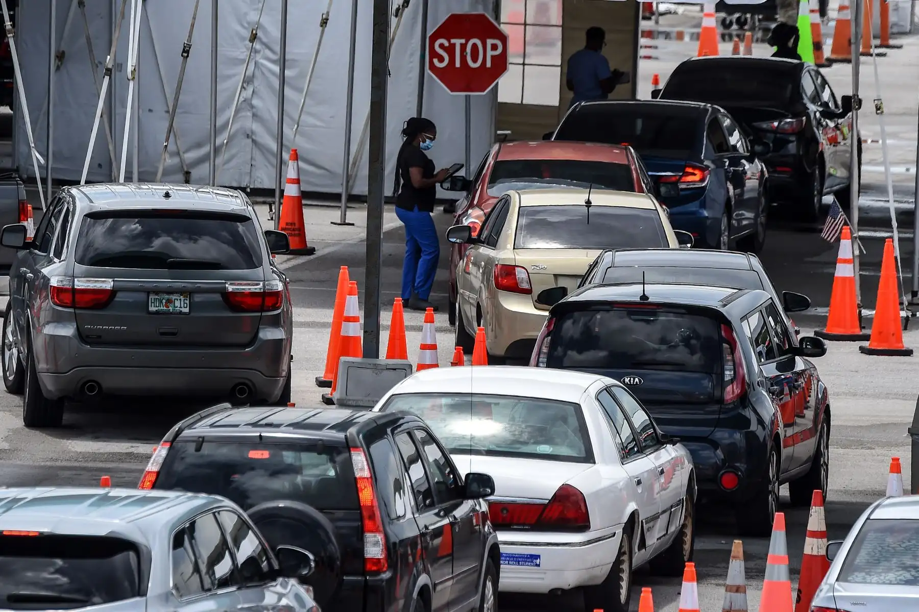 Un miembro del personal médico ayuda a las personas que hacen fila en sus autos en un sitio de prueba rápida de antígeno de coronavirus en el Hard Rock Stadium en Miami.
Foto: AFP