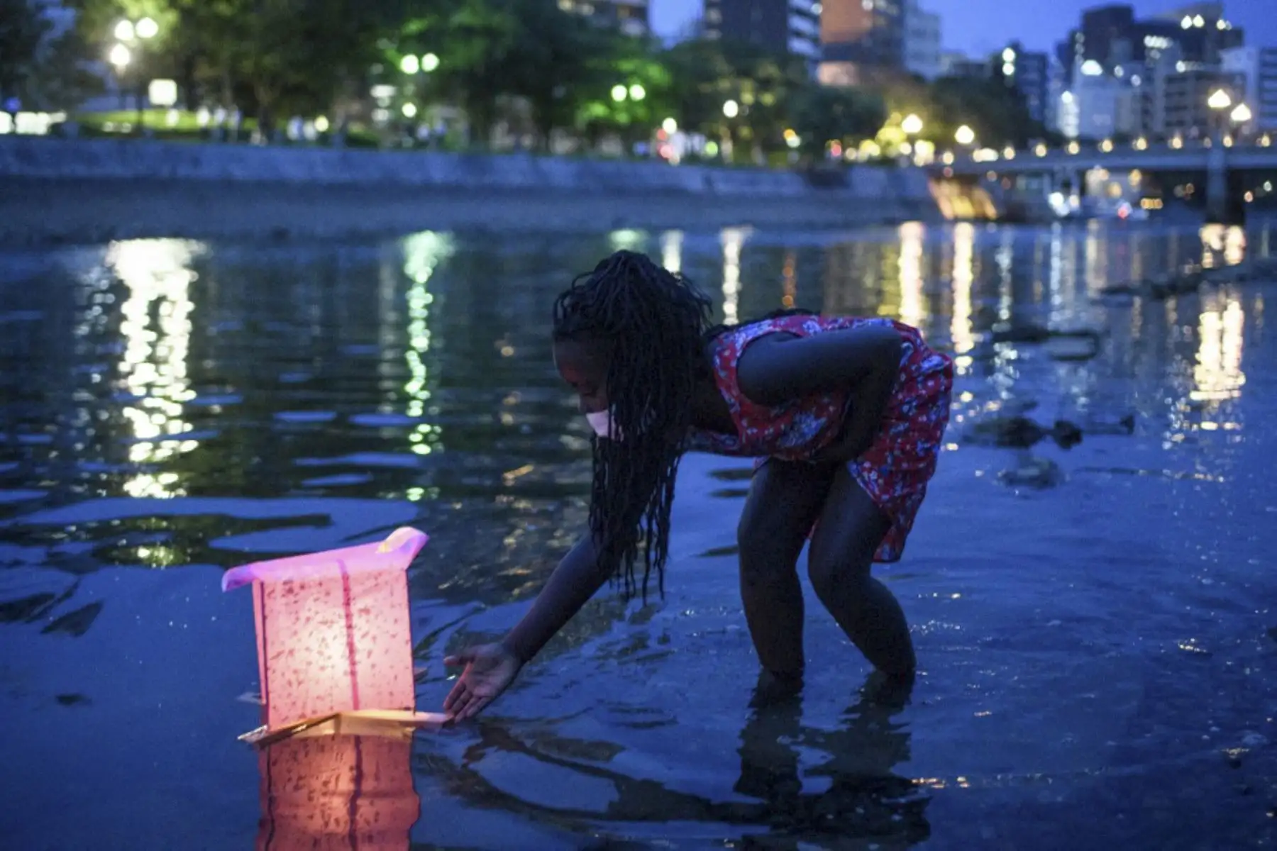 Una niña lanza una linterna de papel en el río Motoyasu en Hiroshima Japón.En el marco de los  75 años desde el primer ataque con bomba atómica del mundo, con la pandemia de coronavirus se obligó a reducir las ceremonias anuales para conmemorar las víctimas. Foto:AFP
