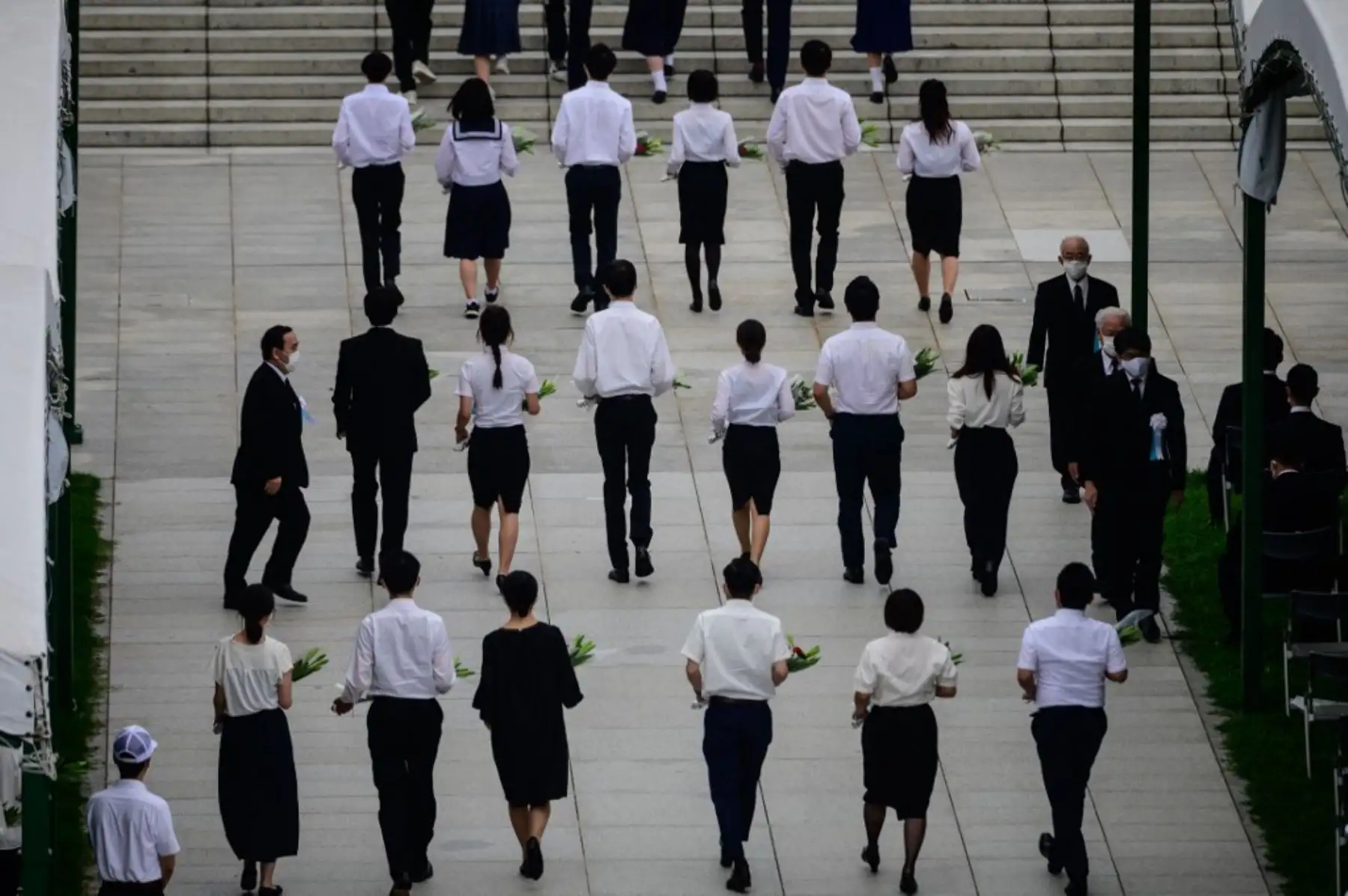 Participantes llevan flores durante el servicio conmemorativo del 75 aniversario para víctimas de bombas atómicas en el Parque Memorial de la Paz en Hiroshima , en el  marco de los 75 años desde el primer ataque con bomba atómica del mundo.Foto:AFP