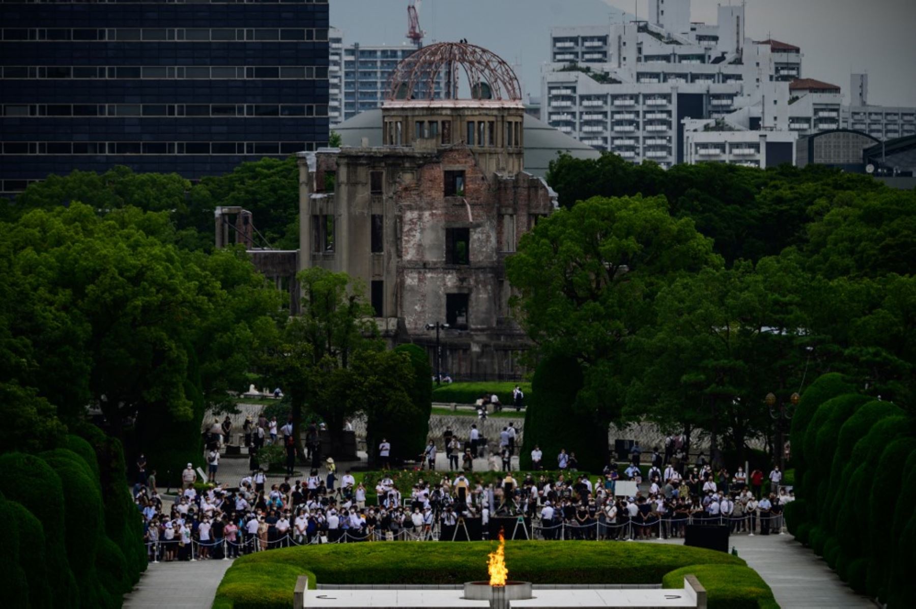 Personas y reporteros se reúnen frente a las ruinas del Salón de Promoción Industrial de la Prefectura de Hiroshima, ahora comúnmente conocida como la cúpula de la bomba atómica, durante el 75ª aniversario de las víctimas de la bomba atómica en el Parque Memorial de la Paz en HiroshimaFoto:AFP
