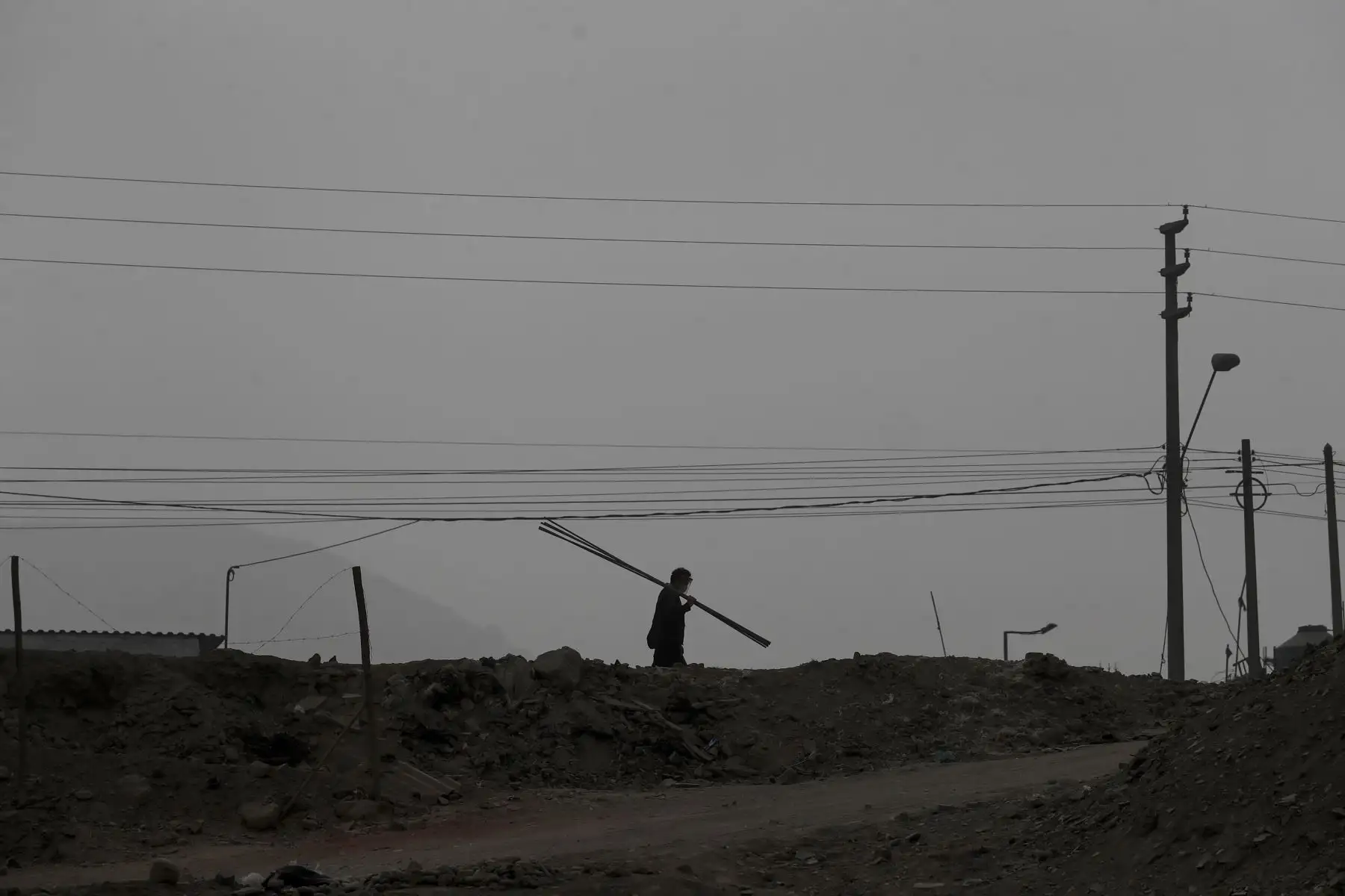 Un trabajador camina con protector facial por las lomas de Manchay. Foto: ANDINA/Renato Pajuelo