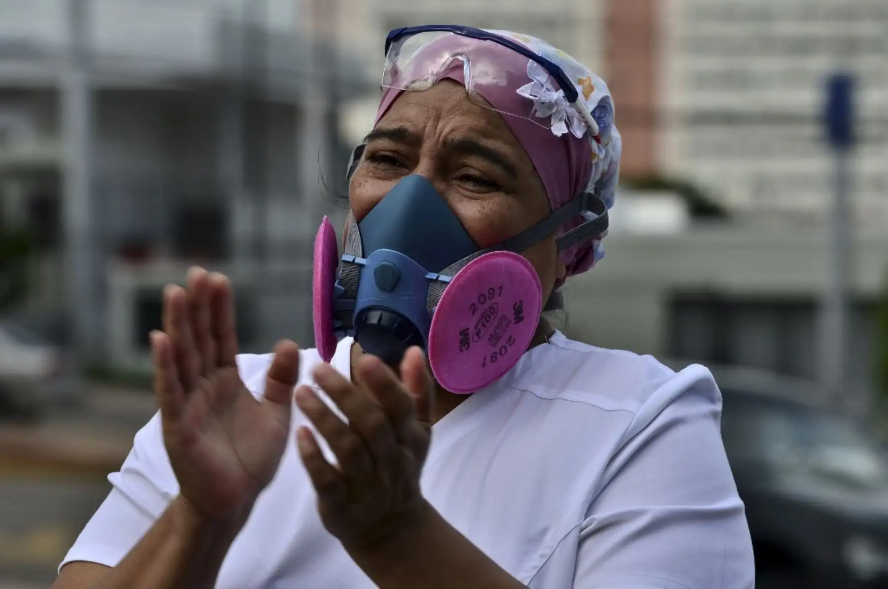 Un colega aplaude durante el funeral de un enfermero del Instituto Hondureño de Seguridad Social, que murió de covid-19, en Tegucigalpa. Foto: AFP