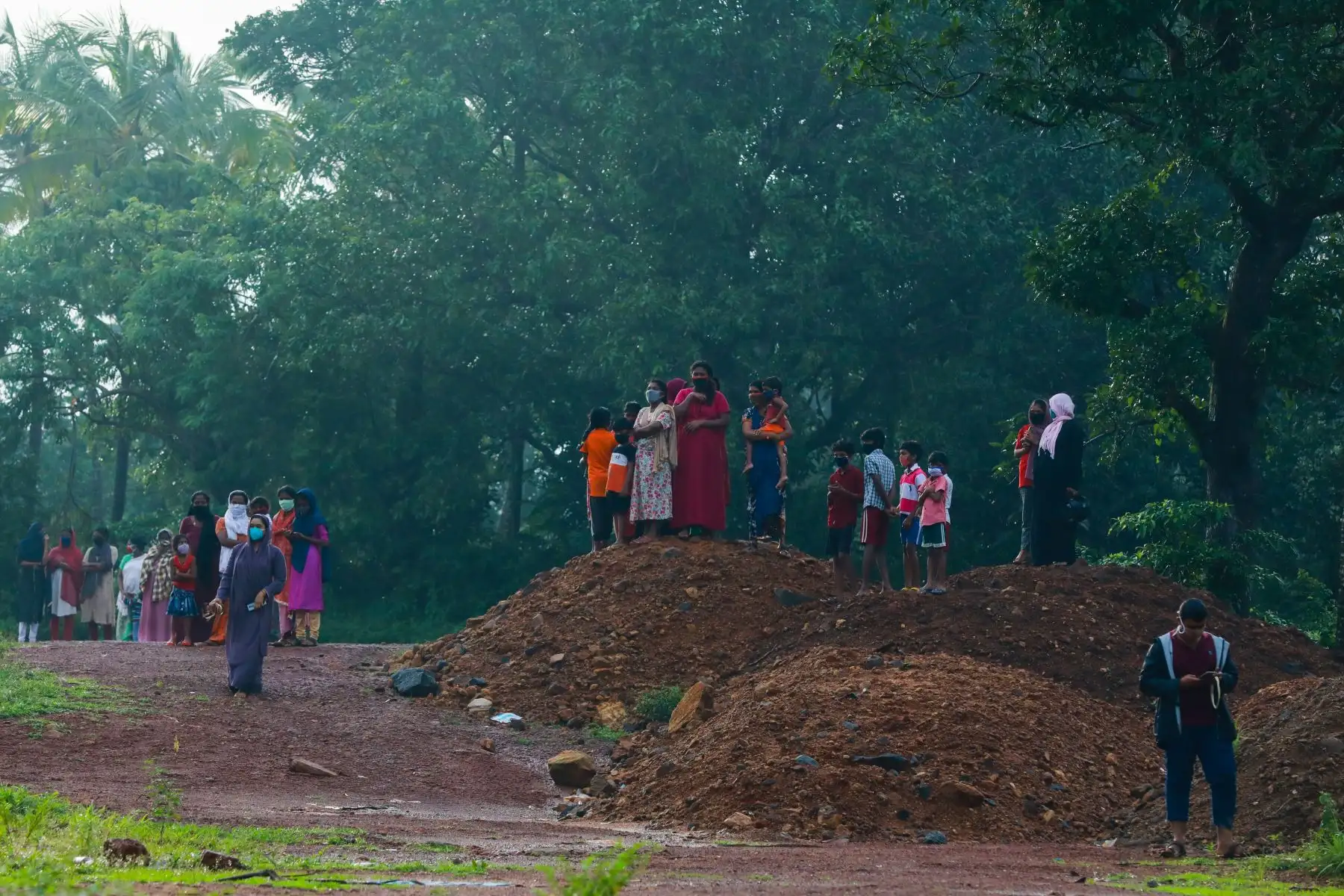 Un grupo de personas observan la inspección los restos del avión de Air India Express tras sufrir accidente. Foto: AFP