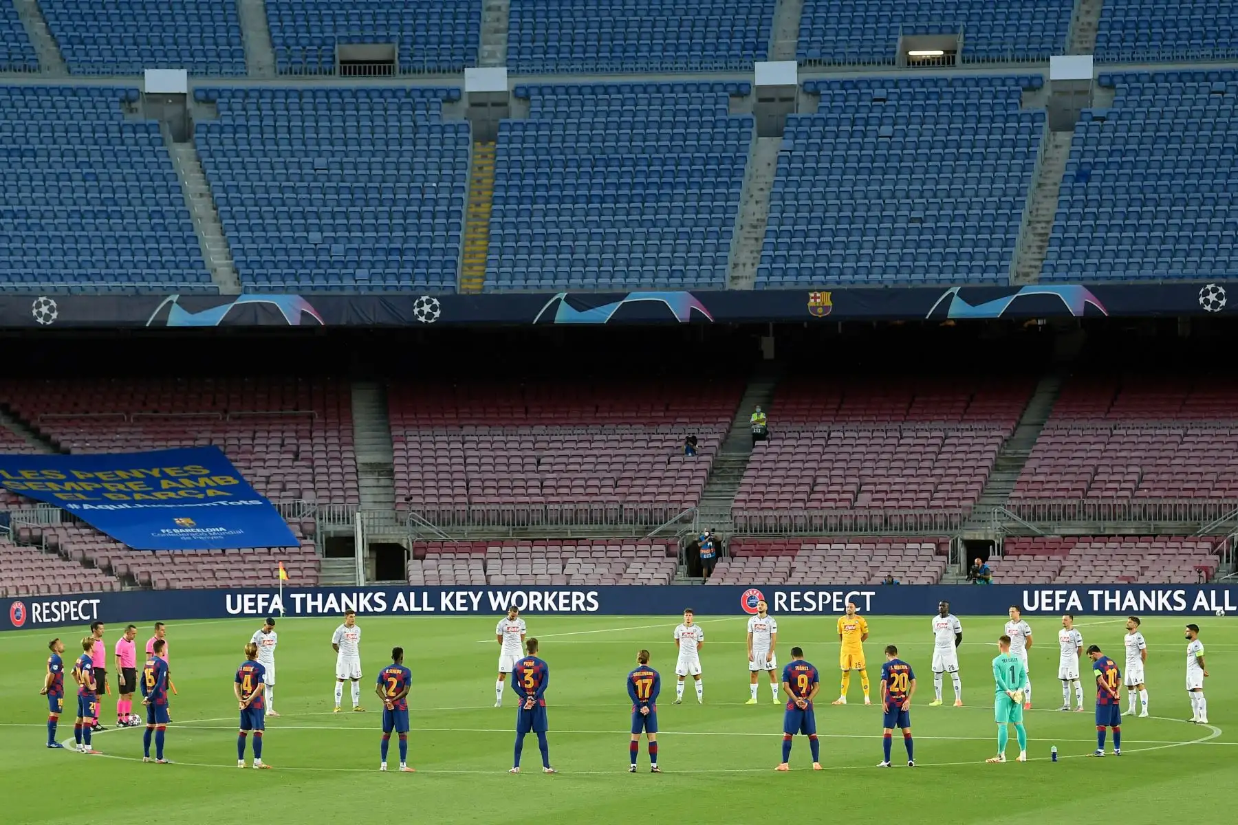 Los jugadores de equipo de Napoli y Barcelona hacen una pausa para un minuto de silencio por las víctimas de la pandemia Covid-19. Foto: AFP