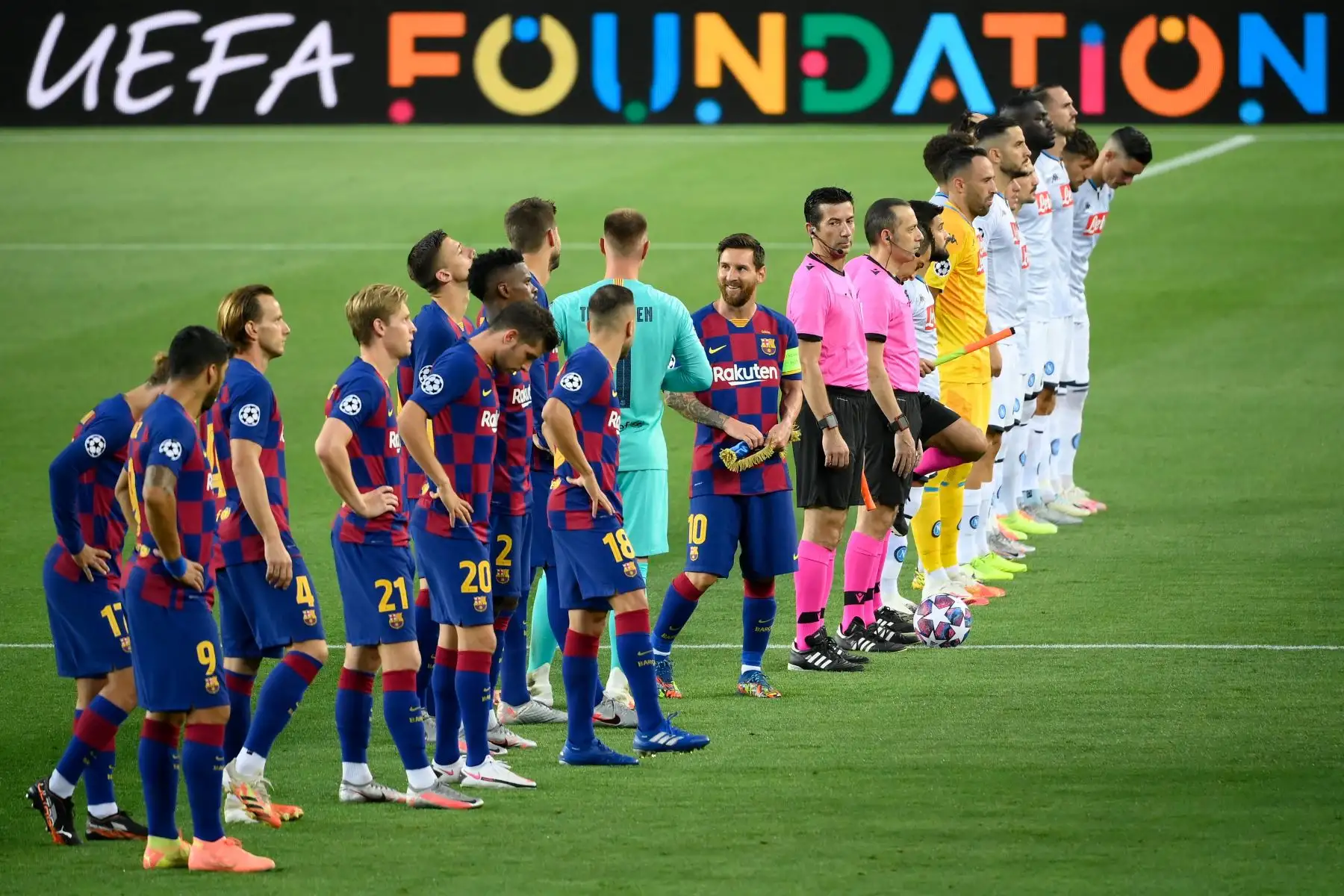 El delantero argentino del Barcelona, Lionel Messi, sonríe cuando llega a la cancha flanqueado por los jugadores de su equipo y por los jugadores del Napoli. Foto: AFP