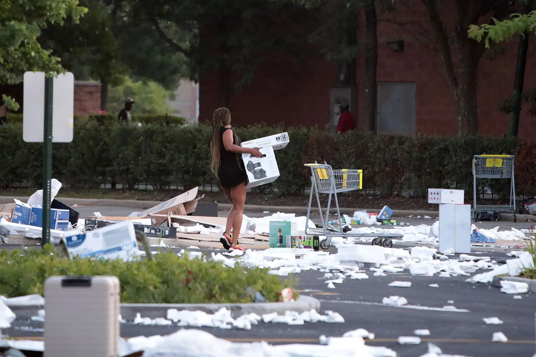 Una persona se lleva una caja de artefactos de una de las tiendas saqueadas anoche, en Chicago. Foto: AFP