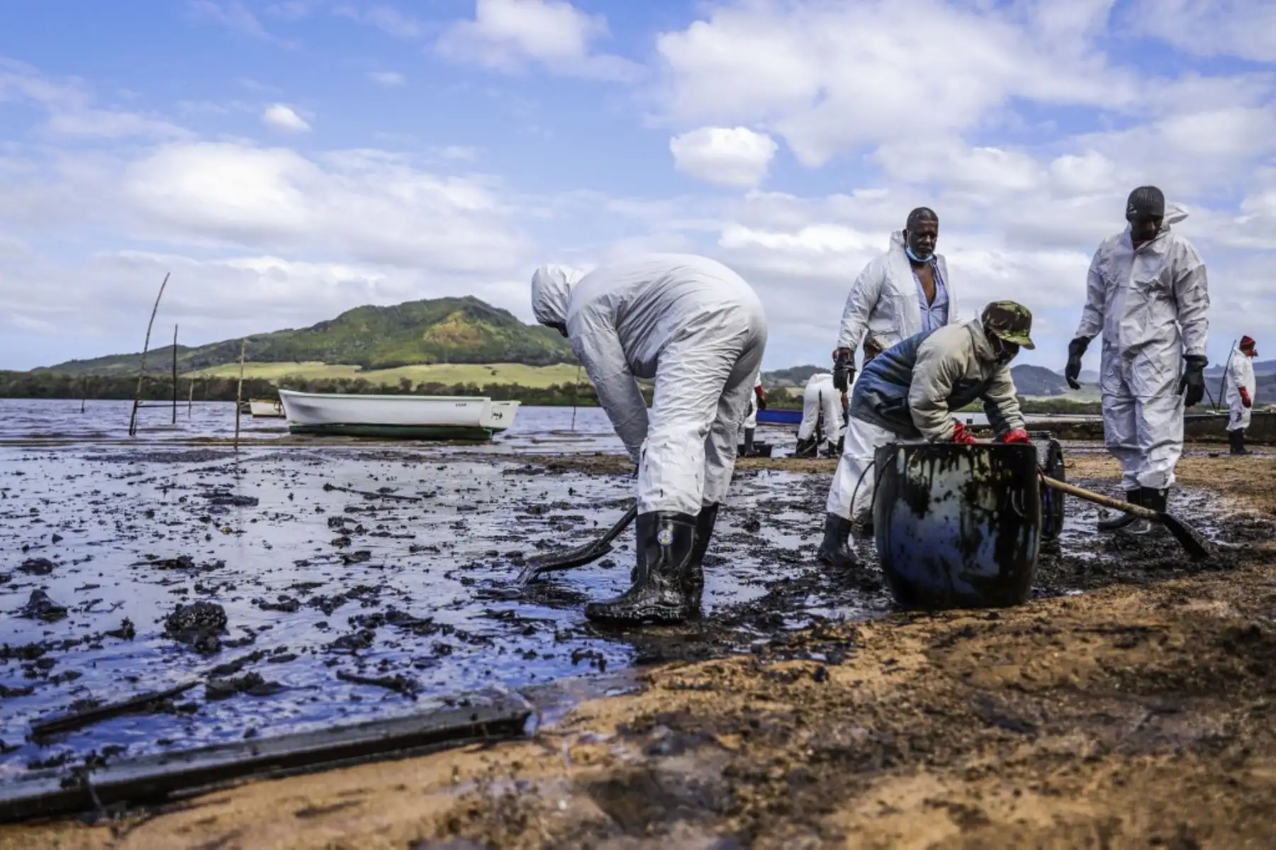 Personas extraen aceite derramado del buque MV Wakashio, perteneciente a una empresa japonesa que encalló y provocó una fuga de petróleo cerca del Blue Bay Marine Park. Foto: AFP