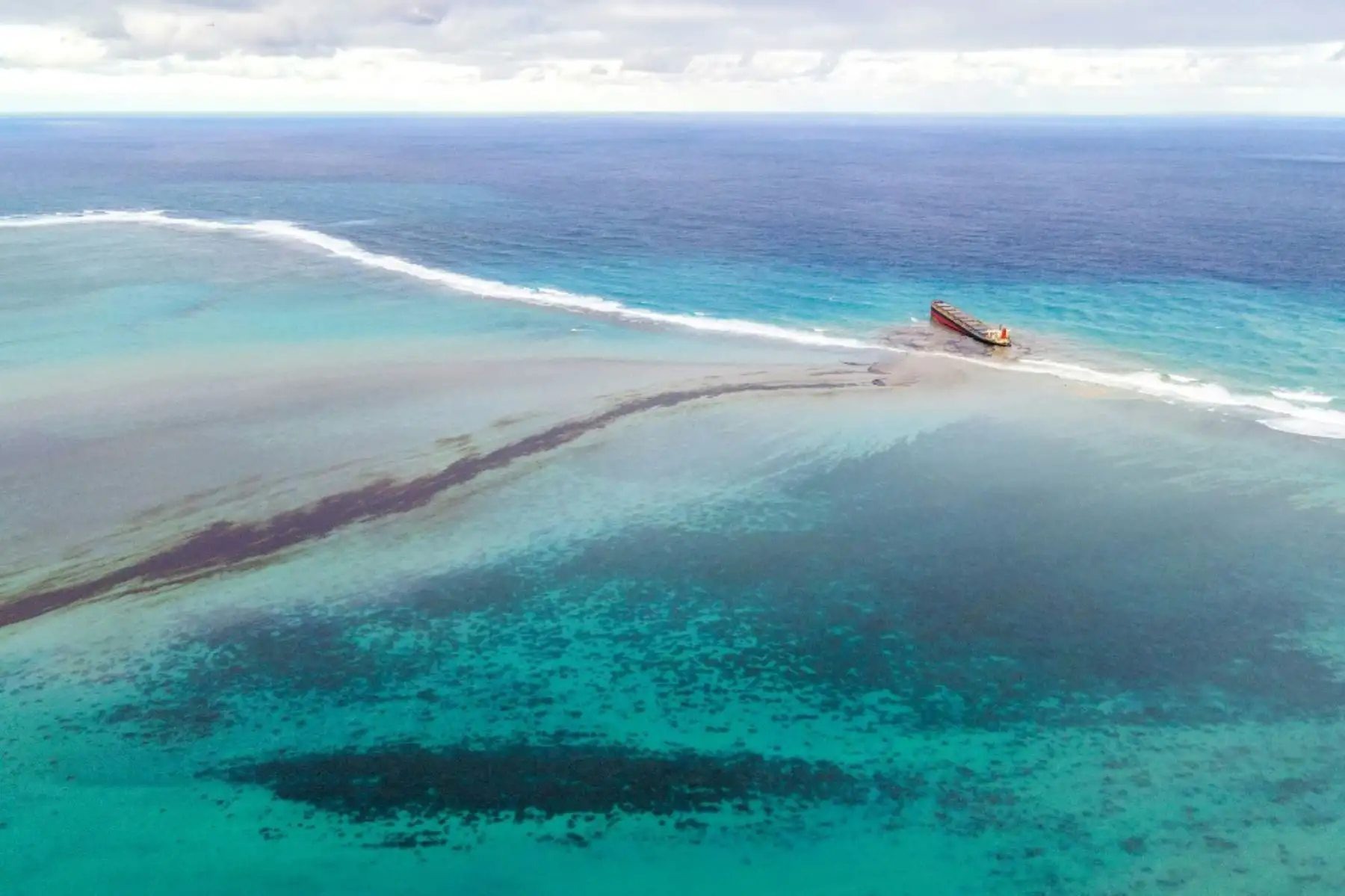 Esta vista aérea muestra una gran mancha de petróleo derramado y el buque MV Wakashio, perteneciente a una empresa japonesa que encalló cerca del Blue Bay Marine Park frente a las costas del sureste. Mauricio. Foto: AFP