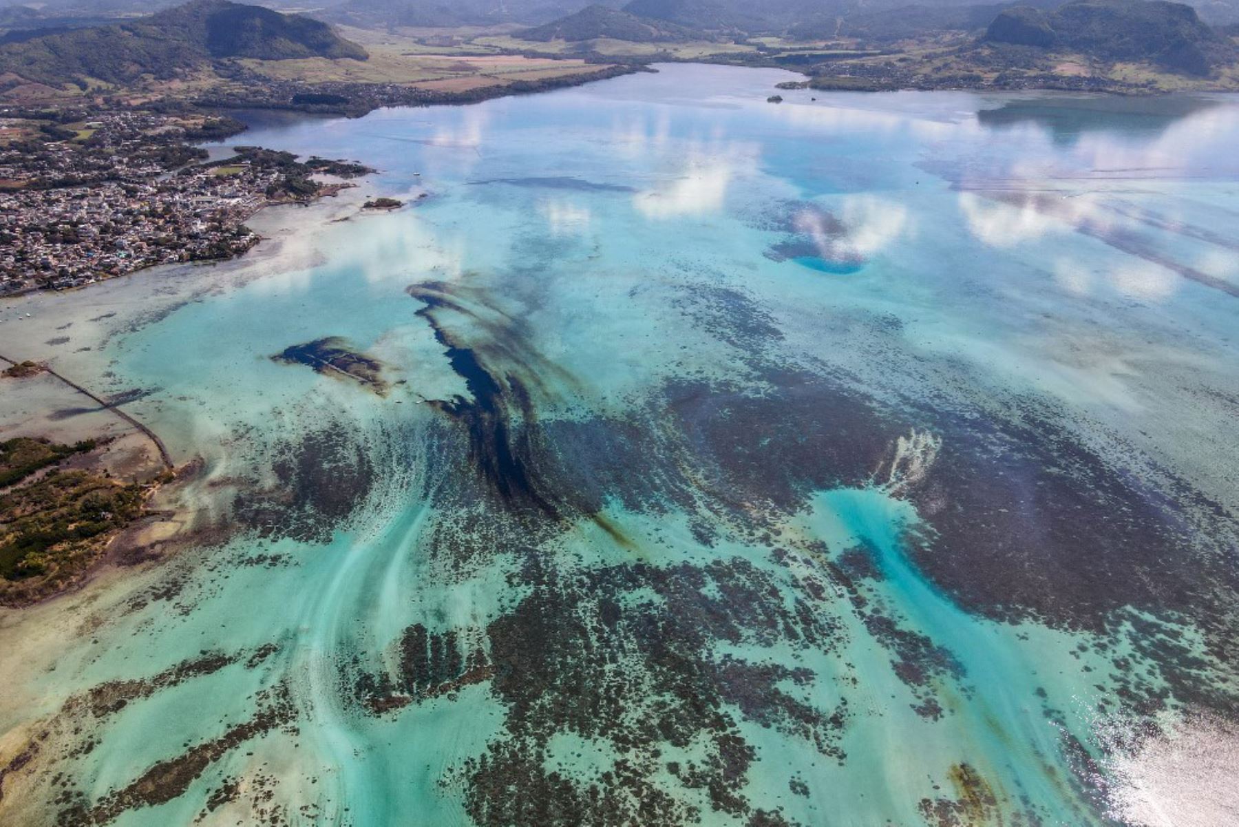 Esta vista aérea muestra una gran mancha de petróleo derramado y el buque MV Wakashio, perteneciente a una empresa japonesa que encalló cerca del Blue Bay Marine Park frente a las costas del sureste. Mauricio. Foto: AFP
