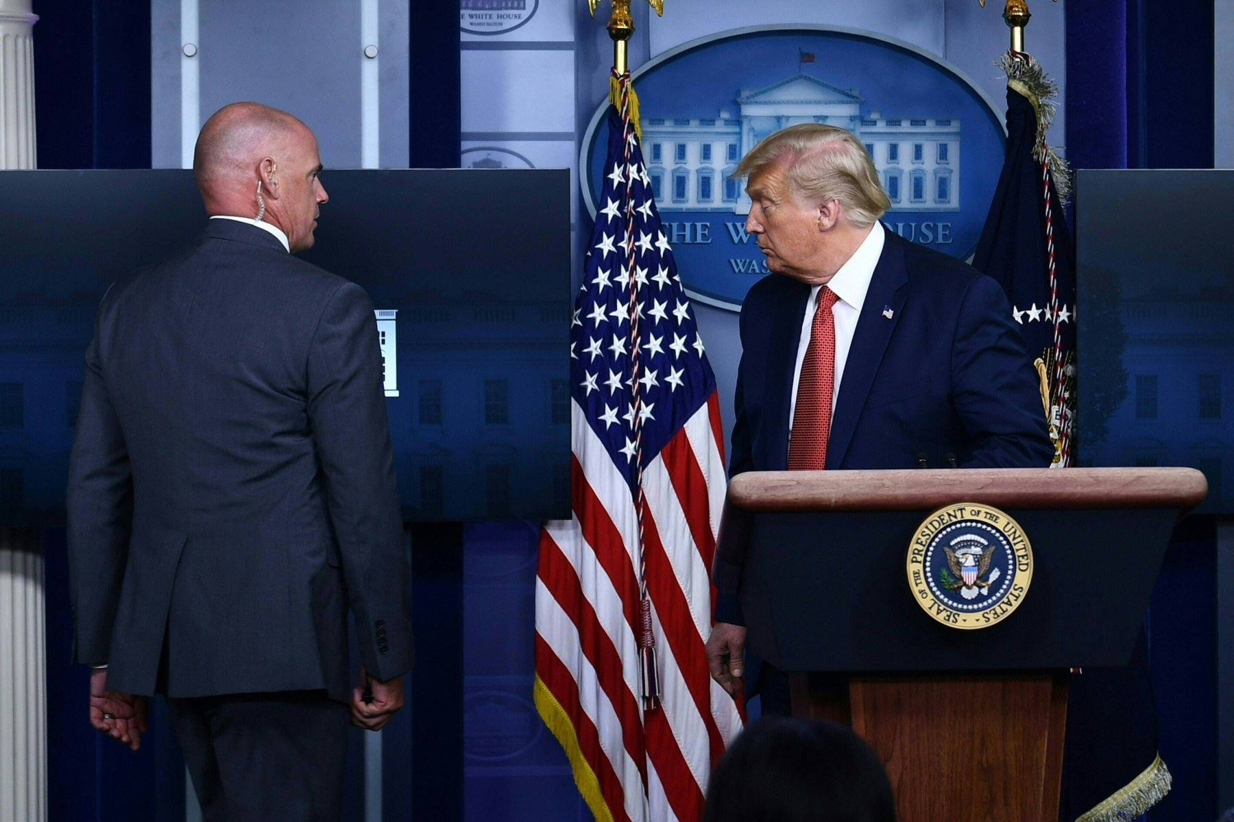 El presidente de los Estados Unidos, Donald Trump, está siendo escoltado por un miembro del Servicio Secreto de la Sala Brady Briefing de la Casa Blanca en Washington. Foto: AFP