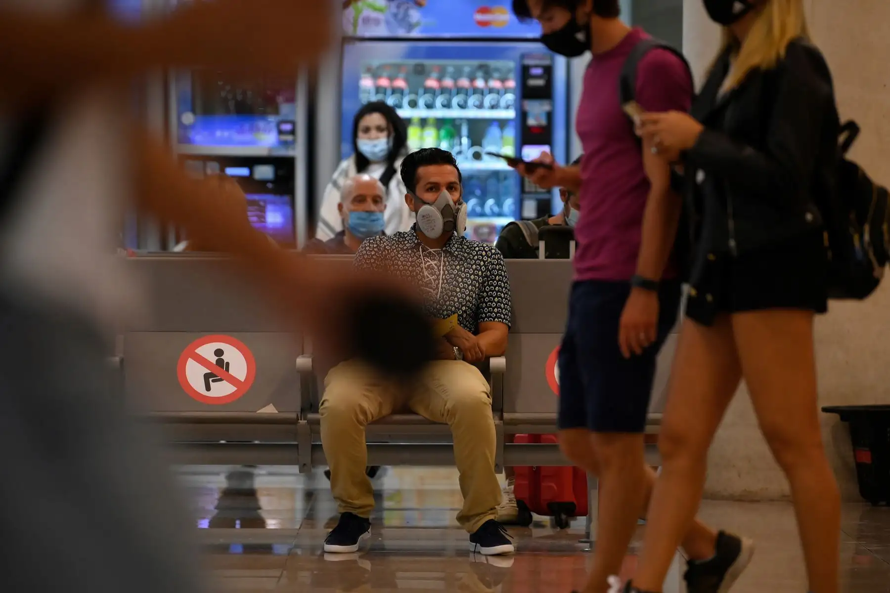 Un hombre con mascarilla espera su vuelo en el aeropuerto de El Prat en Barcelona .
Foto: AFP