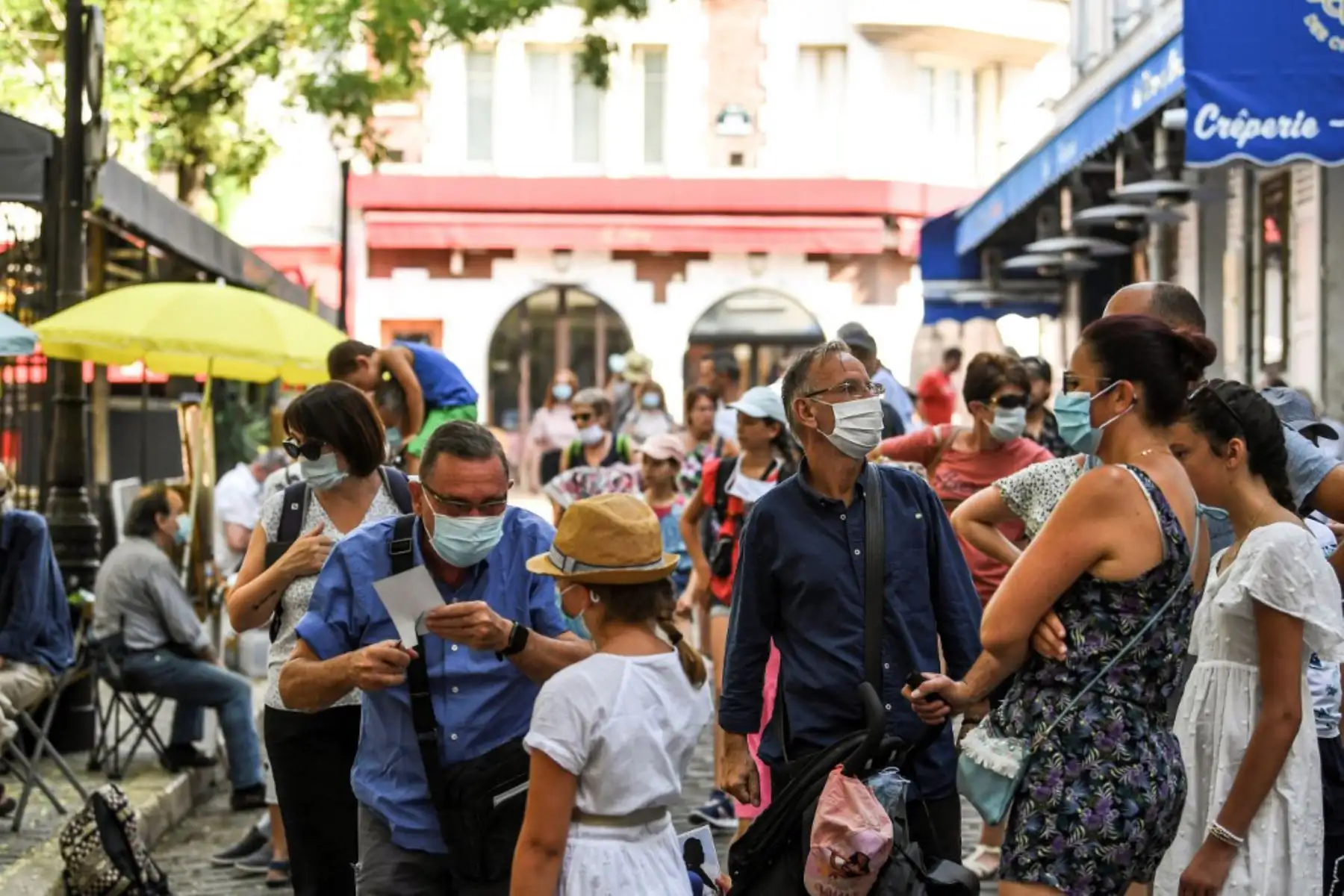 Personas usando mascarillas protectoras visitan el barrio de Montmartre, en París. El alcalde decidió hacer obligatoria la mascarilla en determinadas zonas de la ciudad para luchar contra el aumento de nuevos casos infectados de covid-19 

Foto: AFP