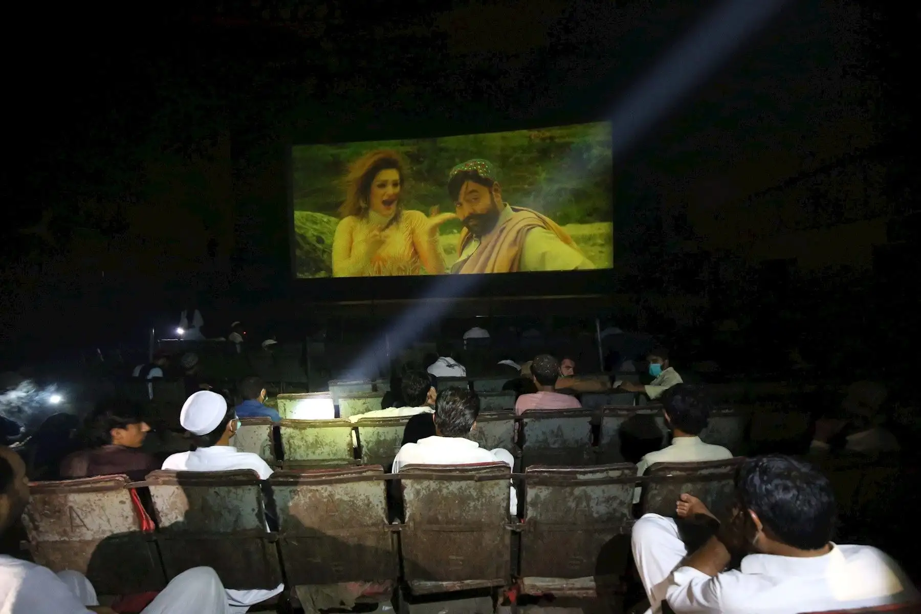 Gente viendo una película en el cine después de que el gobierno levantara la mayoría de las restricciones de coronavirus restantes en el país, en Peshawar, Pakistán.

Foto: EFE