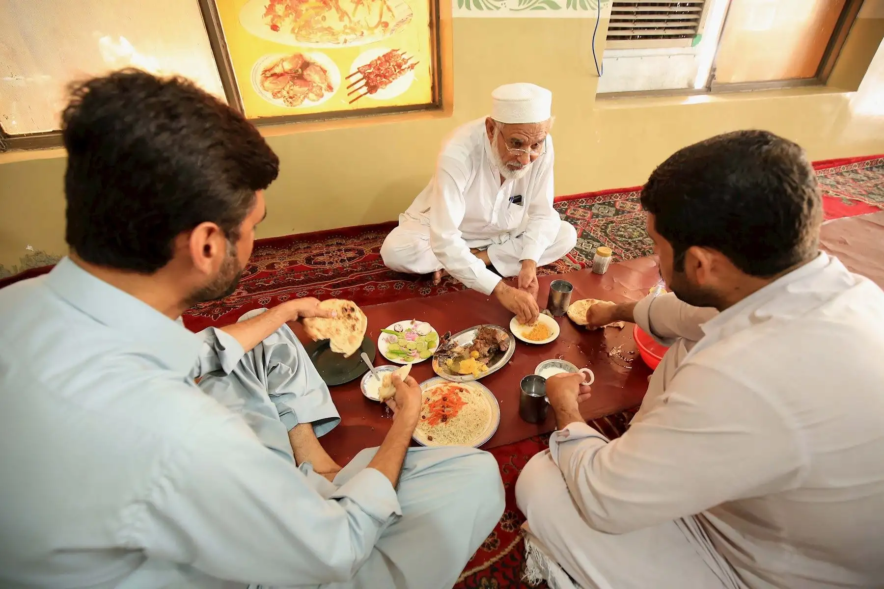 Personas sin mascarillas comparten alimentos después de que el gobierno levantara la mayoría de las restricciones de coronavirus restantes en el país, en Peshawar, Pakistán.

Foto: EFE
