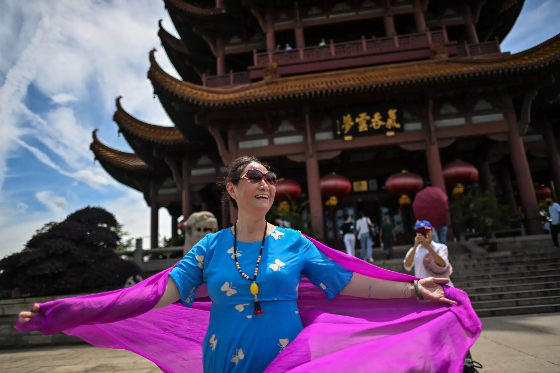 Mujer visita la Torre de la Grulla Amarilla en Wuhan, sin el uso de una mascarilla. Las largas filas de clientes ahora se extienden fuera de los puestos de desayuno, muy lejos de las multitudes aterrorizadas que hicieron cola en los hospitales de la ciudad en las primeras semanas después de que se impuso un bloqueo en toda la ciudad para frenar la propagación del coronavirus. Foto: AFP