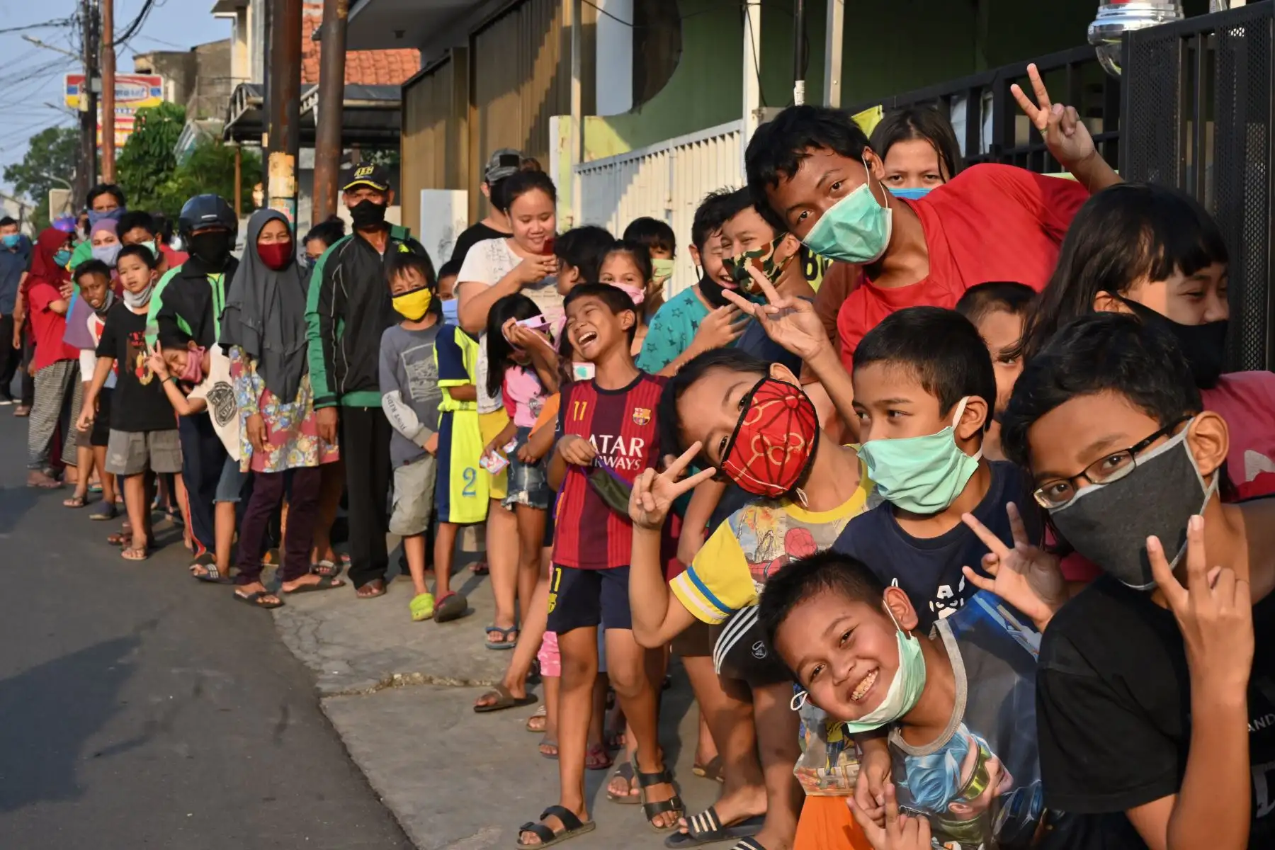 Musulmanes indonesios reaccionan a la fotografía mientras hacen cola para recibir comida gratis y romper su ayuno durante el mes sagrado del Ramadán en Yakarta, Indonesia. Foto: AFP