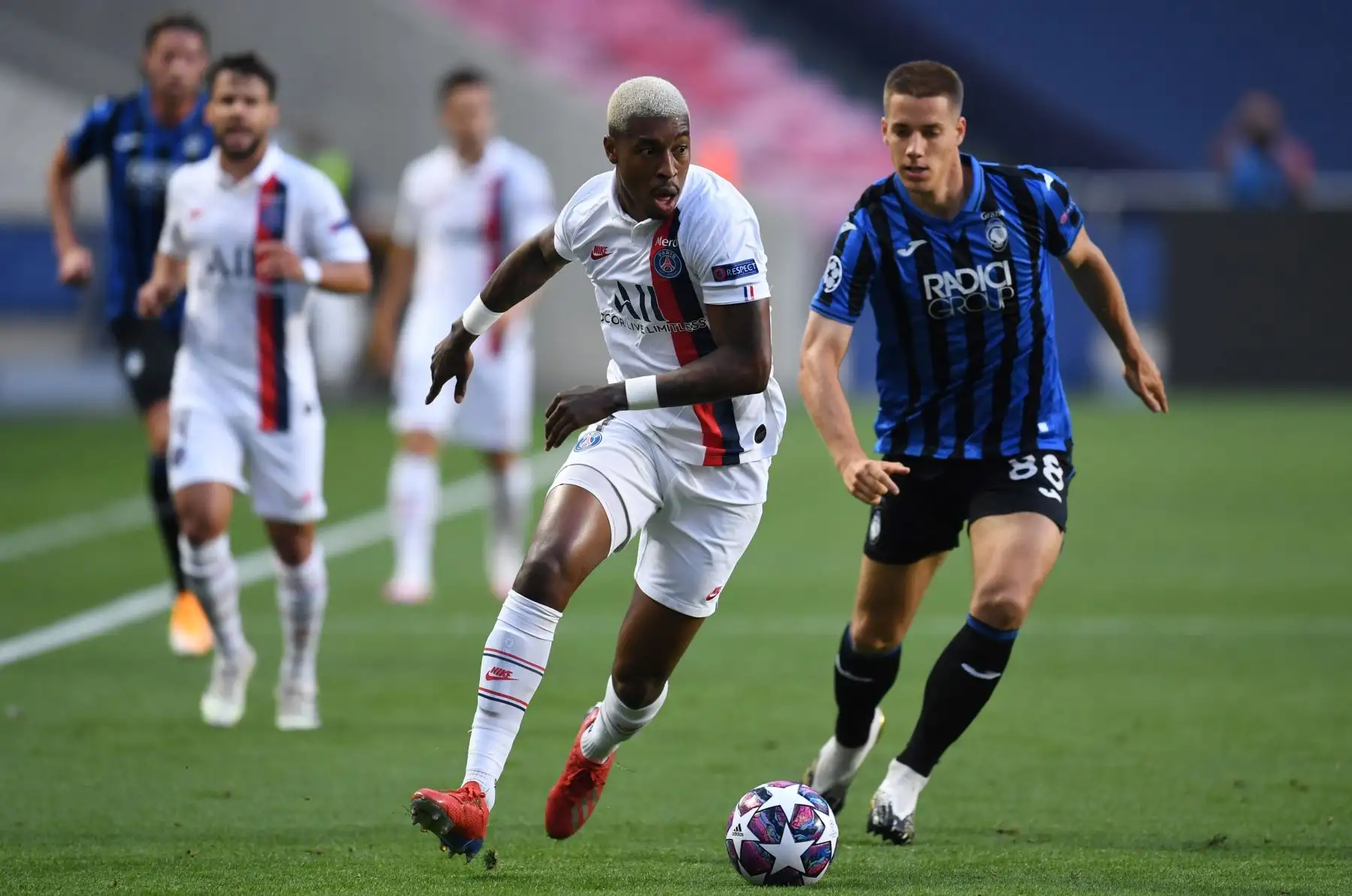 El defensor francés del Paris Saint-Germain, Presnel Kimpembe, lucha por el balón con el mediocampista croata de Atalanta, Mario Pasalic, durante el partido de fútbol de cuartos de final de la UEFA Champions League. Foto: AFP