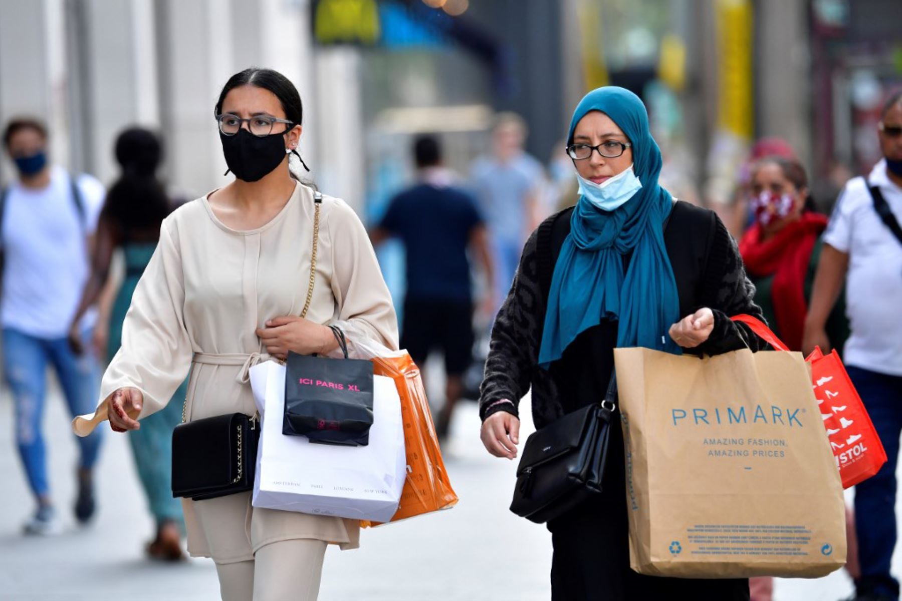 Mujeres se cubren la cara total o parcialmente con una mascarilla protectora mientras caminan por el centro de la ciudad de Amberes, Bélgica.

Foto: AFP