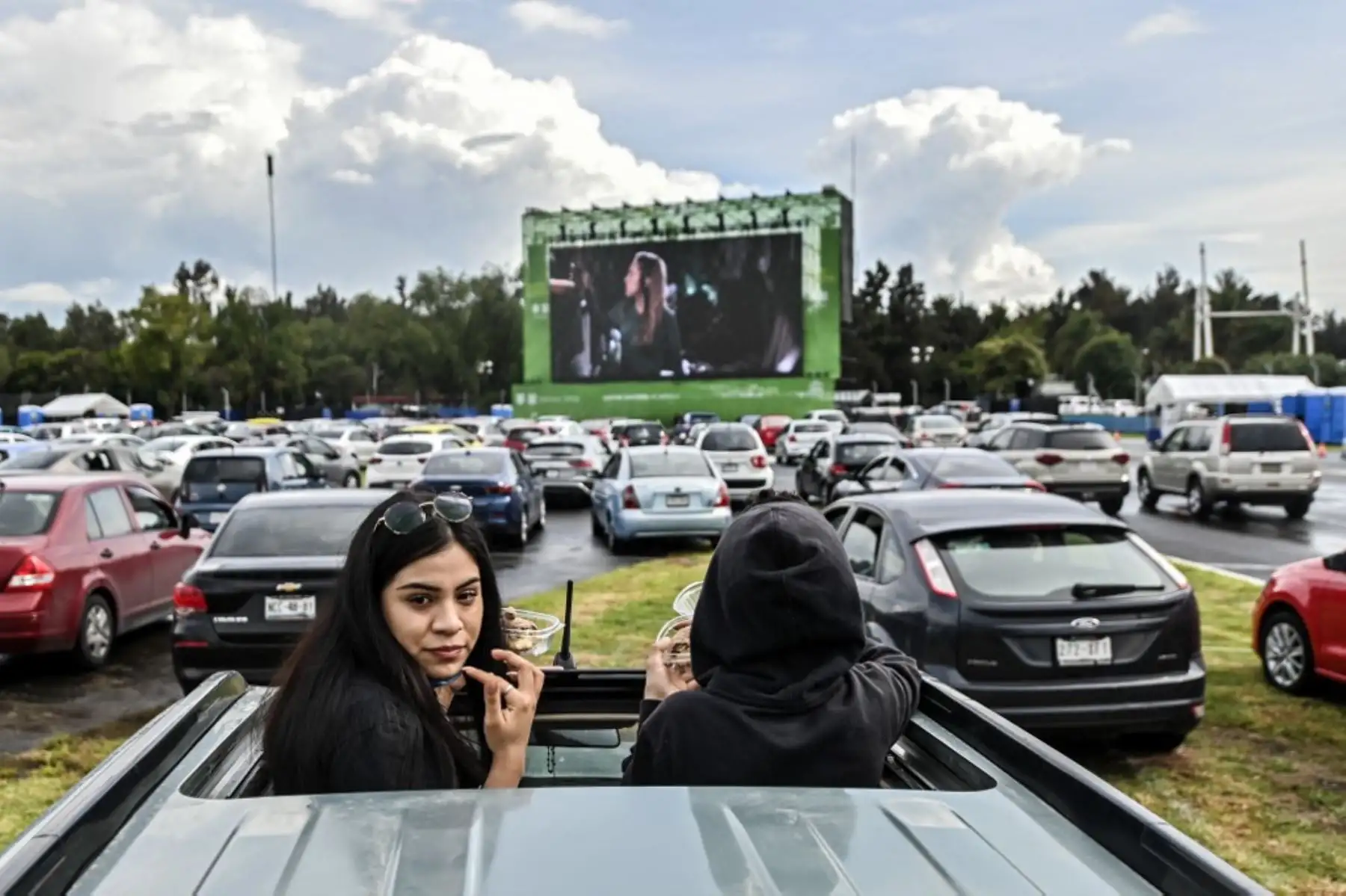 Personas asisten a un autocine instalado en el hipódromo Hermanos Rodríguez en la Ciudad de México, en medio de la pandemia del nuevo coronavirus.

Foto: AFP