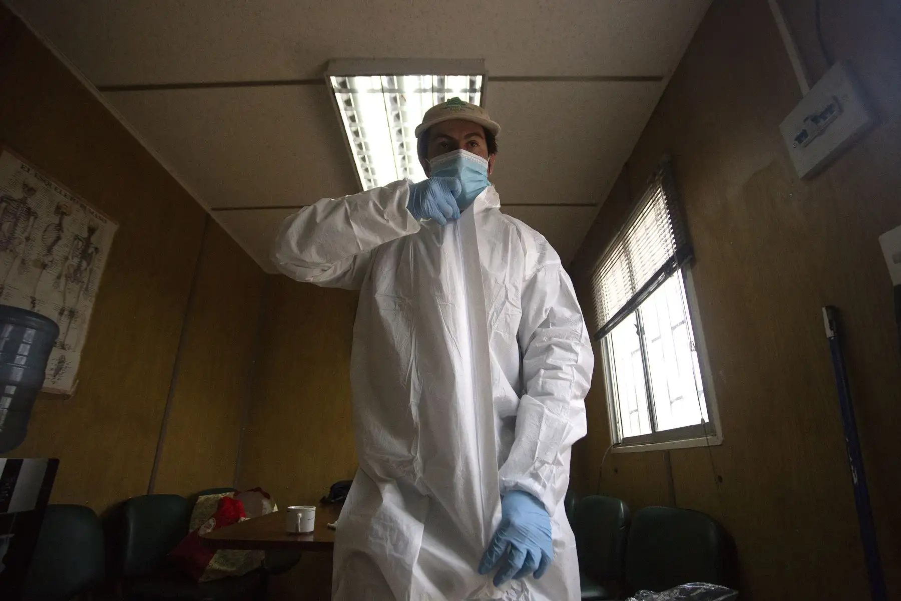 El sepulturero Fernando Quezada, de 27 años, se pone el traje de bioseguridad en el Cementerio General de Santiago en medio de la pandemia del nuevo coronavirus.
Foto: AFP