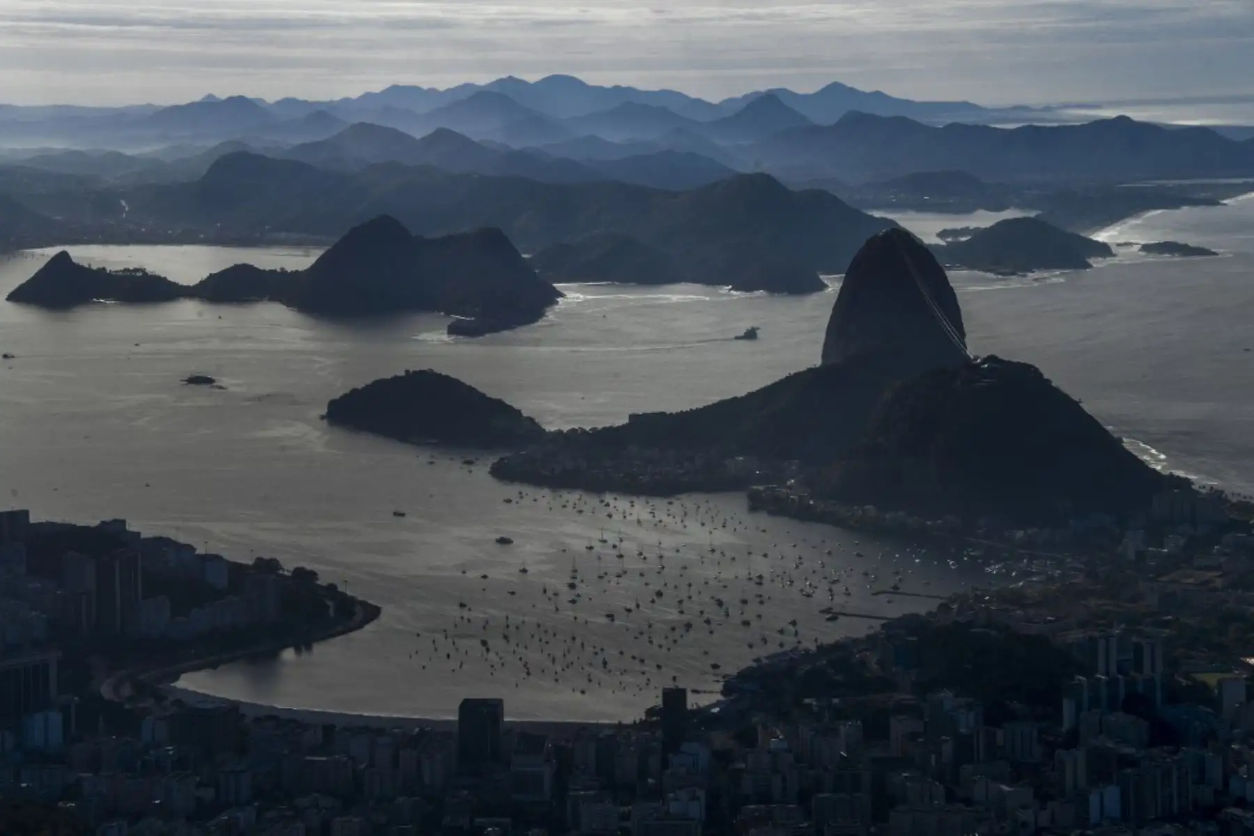Vista general de la ciudad de Río de Janeiro, con el cerro Pan de Azúcar y la Bahía de Guanabara vistas desde el cerro Corcovado durante los procedimientos de desinfección de la estatua del Cristo Redentor en la montaña de Corcovado antes de la inauguración de la atracción turística en Río de Janeiro, Brasil, en medio de la pandemia del nuevo coronavirus.

Foto: AFP