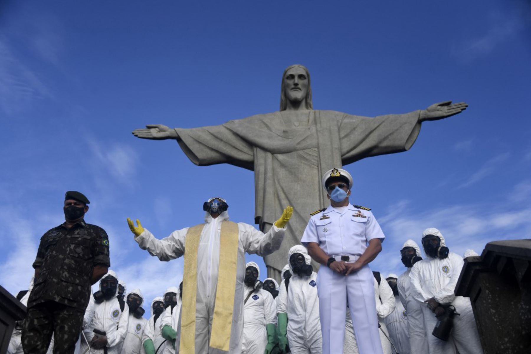 El padre Omar Raposo (C) del Santuario de Corcovado ora entre miembros de las Fuerzas Armadas de Brasil durante la desinfección de la estatua del Cristo Redentor en la montaña de Corcovado, en Río de Janeiro, Brasil

Foto: AFP