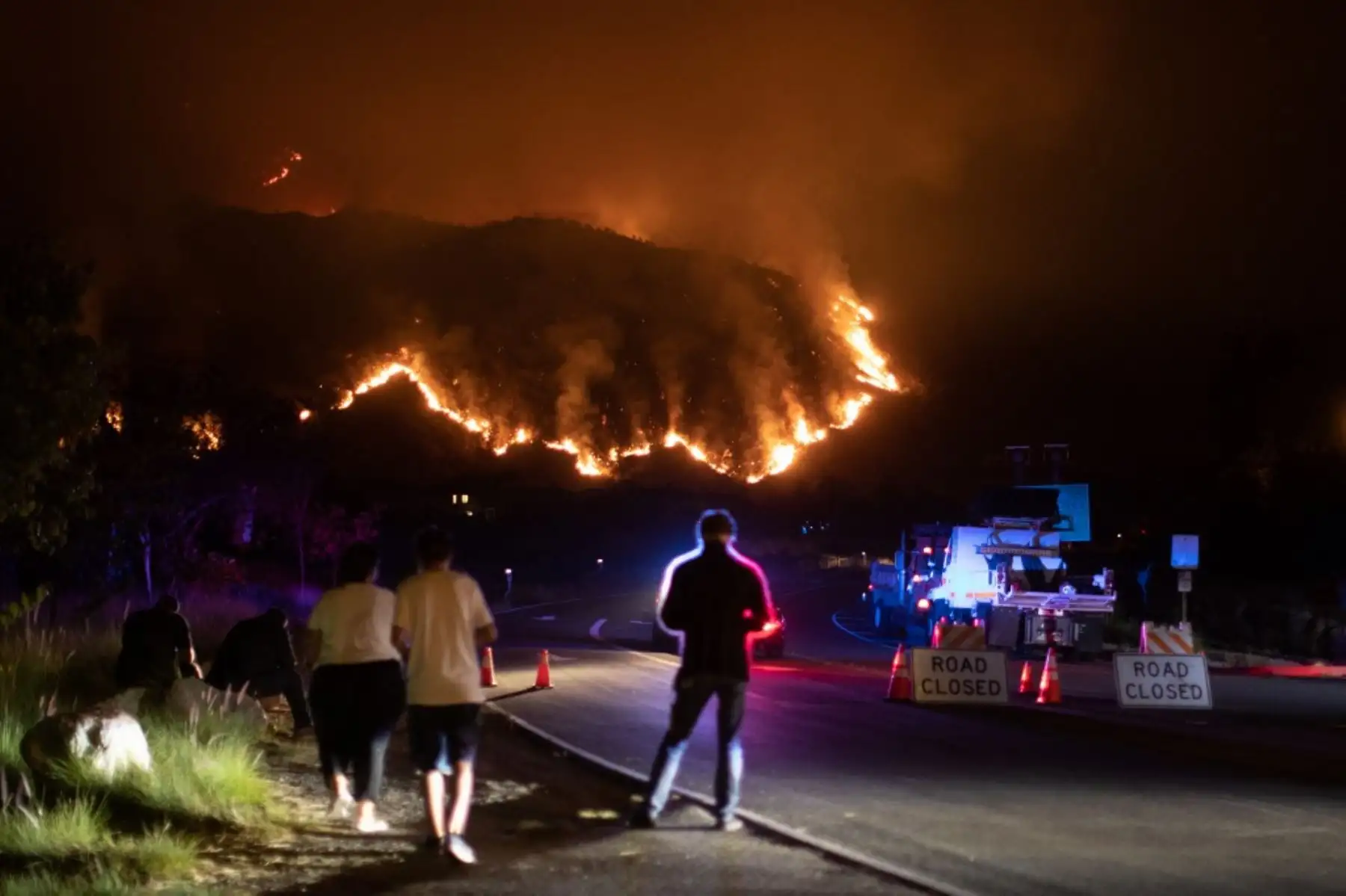 La gente observa el humo y las llamas que se elevan desde el incendio del rancho en las montañas de San Gabriel sobre Azusa, a 25 millas al este de Los Ángeles, California. Foto: AFP