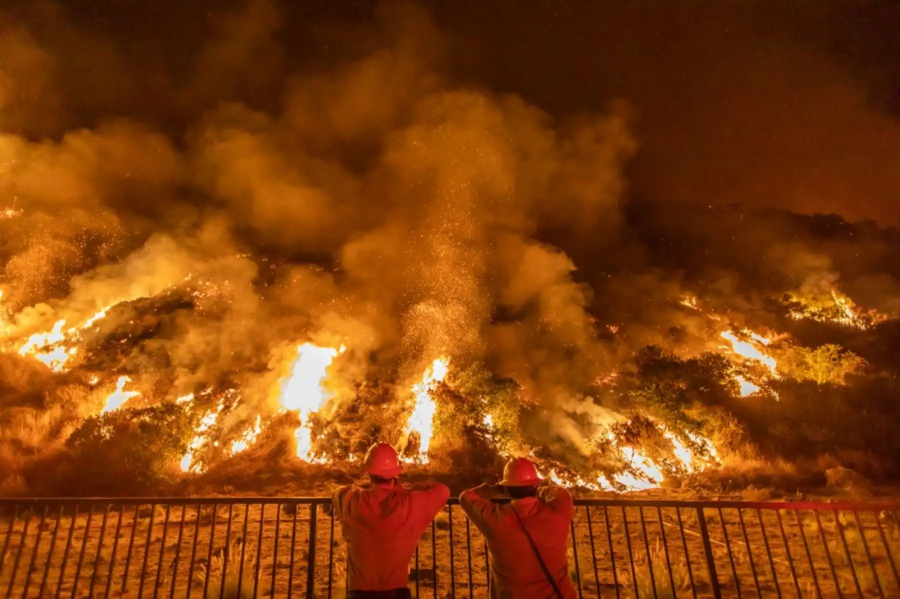 Los bomberos observan el humo y las llamas que se elevan desde las montañas de San Gabriel sobre Azusa, a 25 millas al este de Los Ángeles, California. Foto: AFP