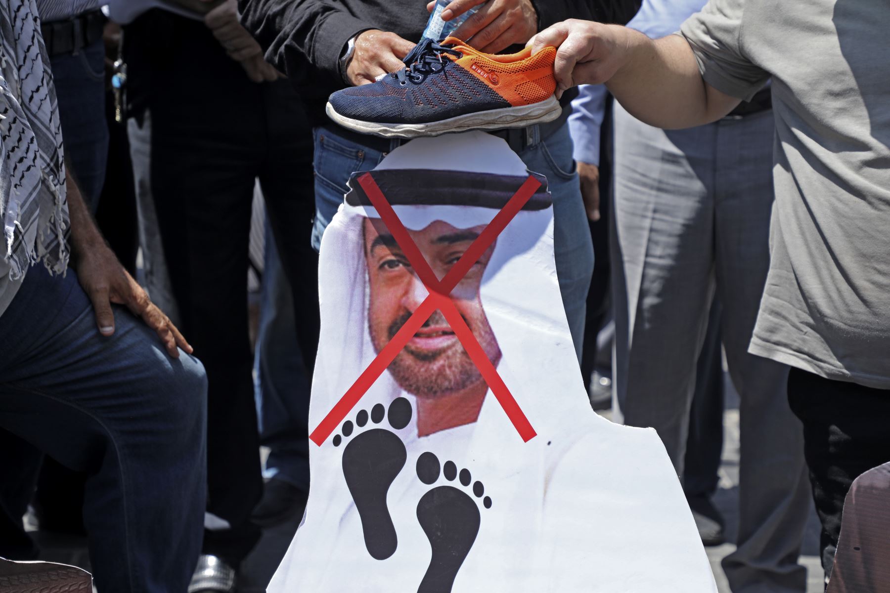 Manifestantes palestinos se preparan para prender fuego a un recorte que muestra el rostro del príncipe heredero de Abu Dhabi, el jeque Mohammed bin Zayed al-Nahyan, durante una manifestación en Naplusa en la ocupada Cisjordania, contra un acuerdo negociado por Estados Unidos entre Israel y los Emiratos Árabes Unidos. Foto: AFP