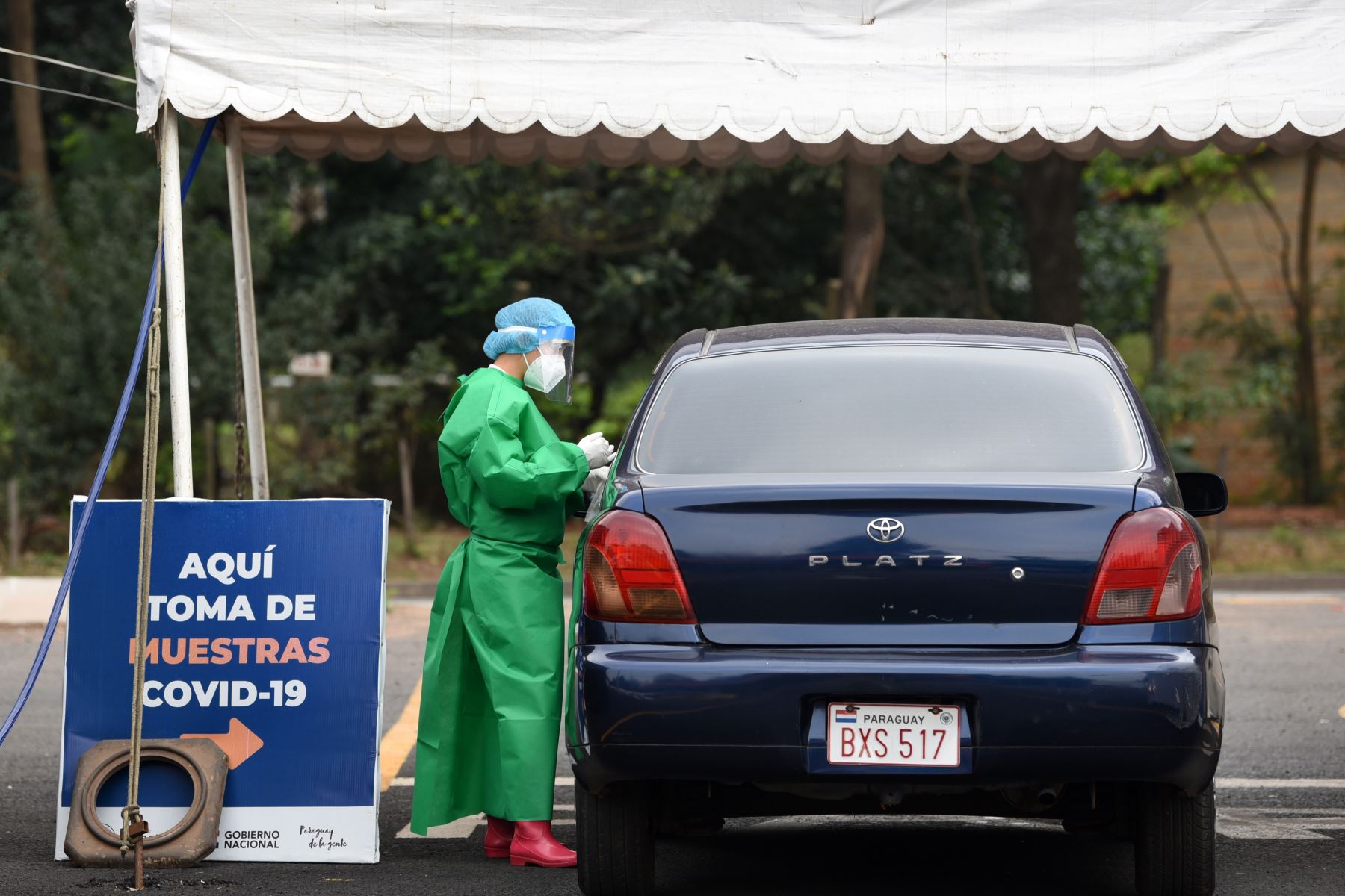 Un trabajador de salud realiza una prueba Covid-19 en un puesto de autoservicio en Asunción, Paraguay. Foto: AFP