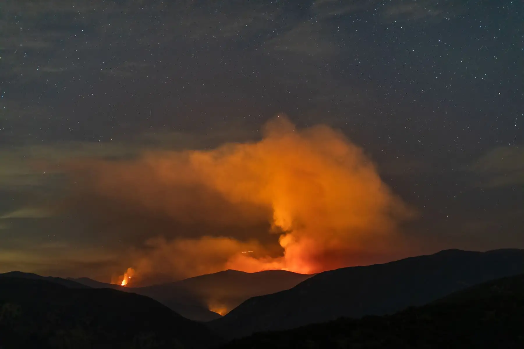 La columna de humo brilla en rojo debido a las llamas que arrasan el Bosque Nacional Ángeles, junto al lago Hughes, a 60 millas al norte de Los Ángeles, California. Foto: AFP