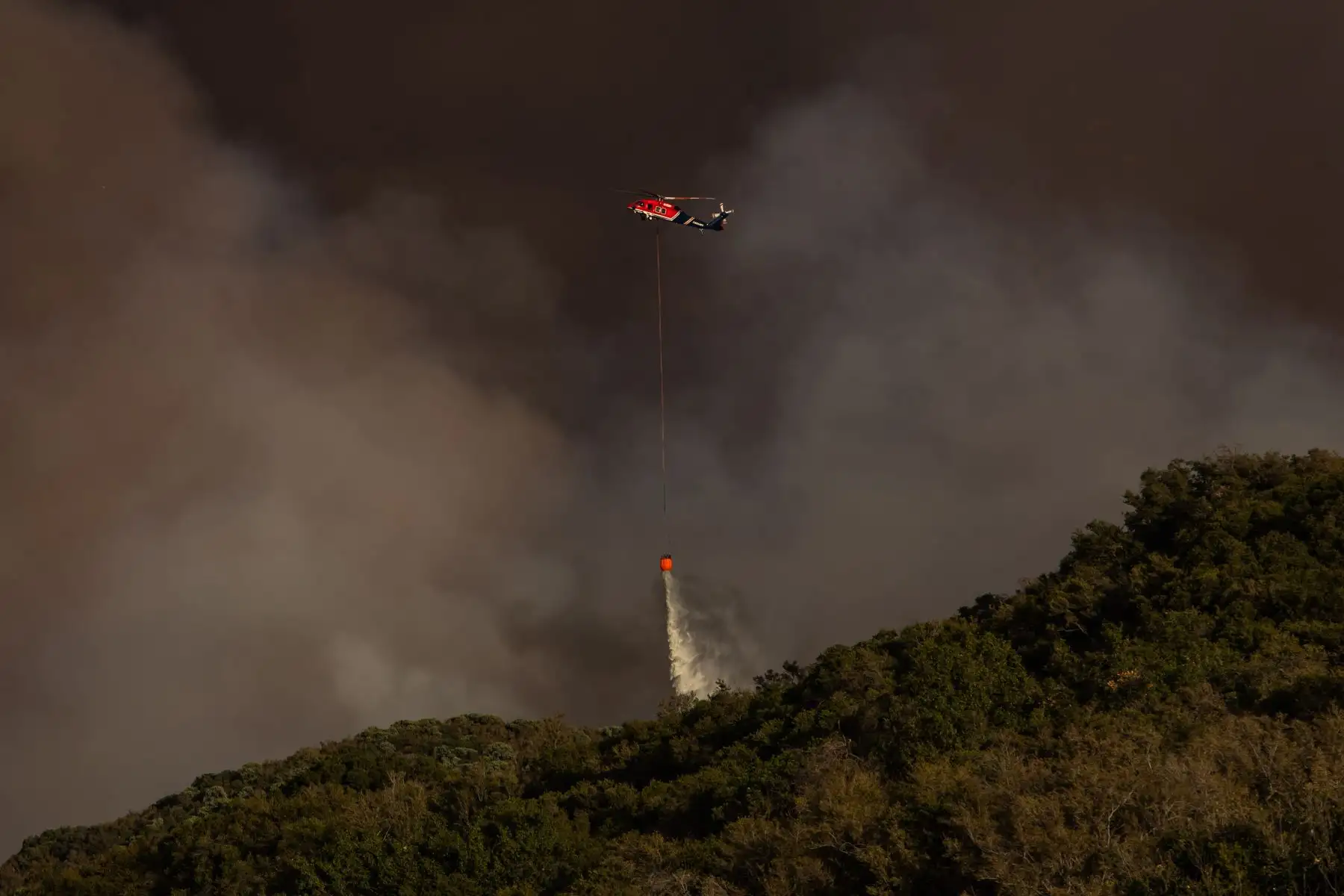 Los helicópteros de extinción de incendios realizan acciones para controlar las llamas en el Bosque Nacional de Ángeles. Foto: AFP