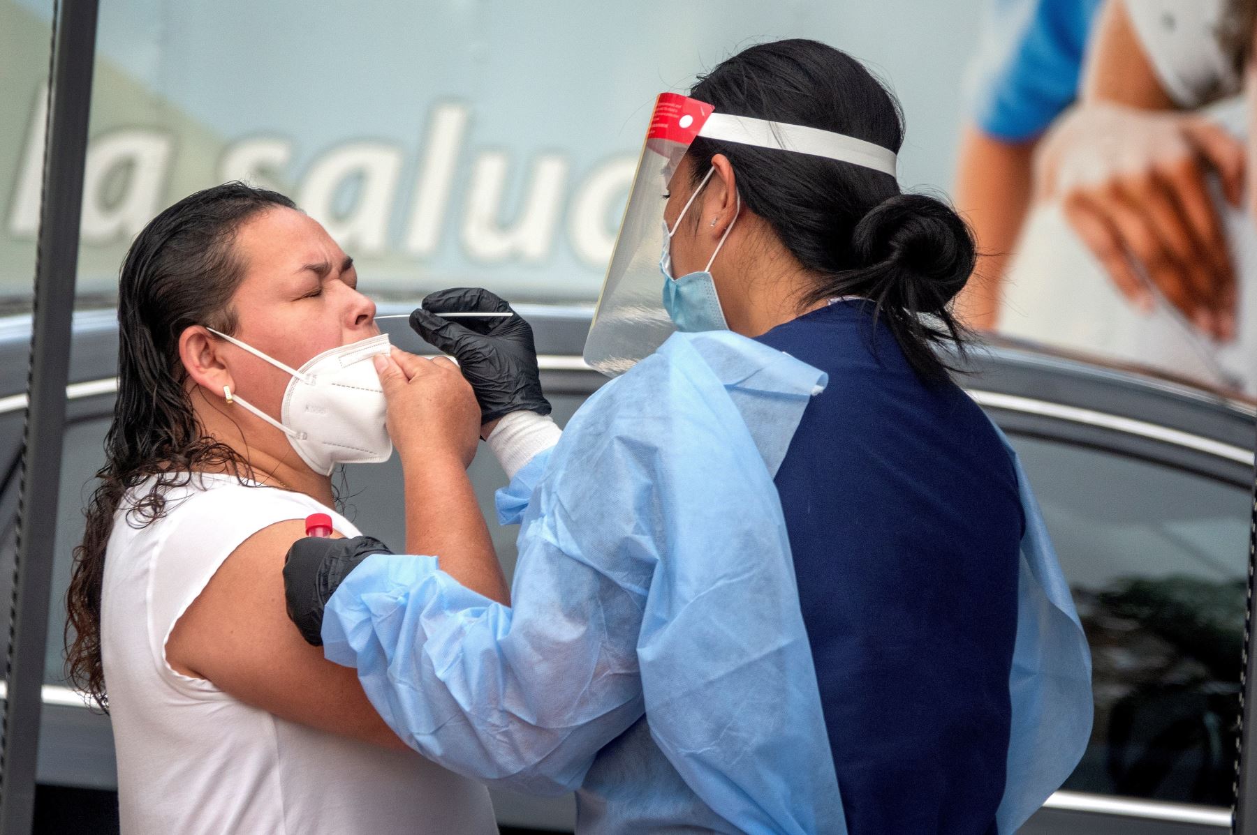 Una mujer recibe su prueba de hisopo recolectada por un miembro del equipo de laboratorios LAB24 para detección de Covid-19, en el estacionamiento del Consulado de México en Miami, Florida. Foto: EFE