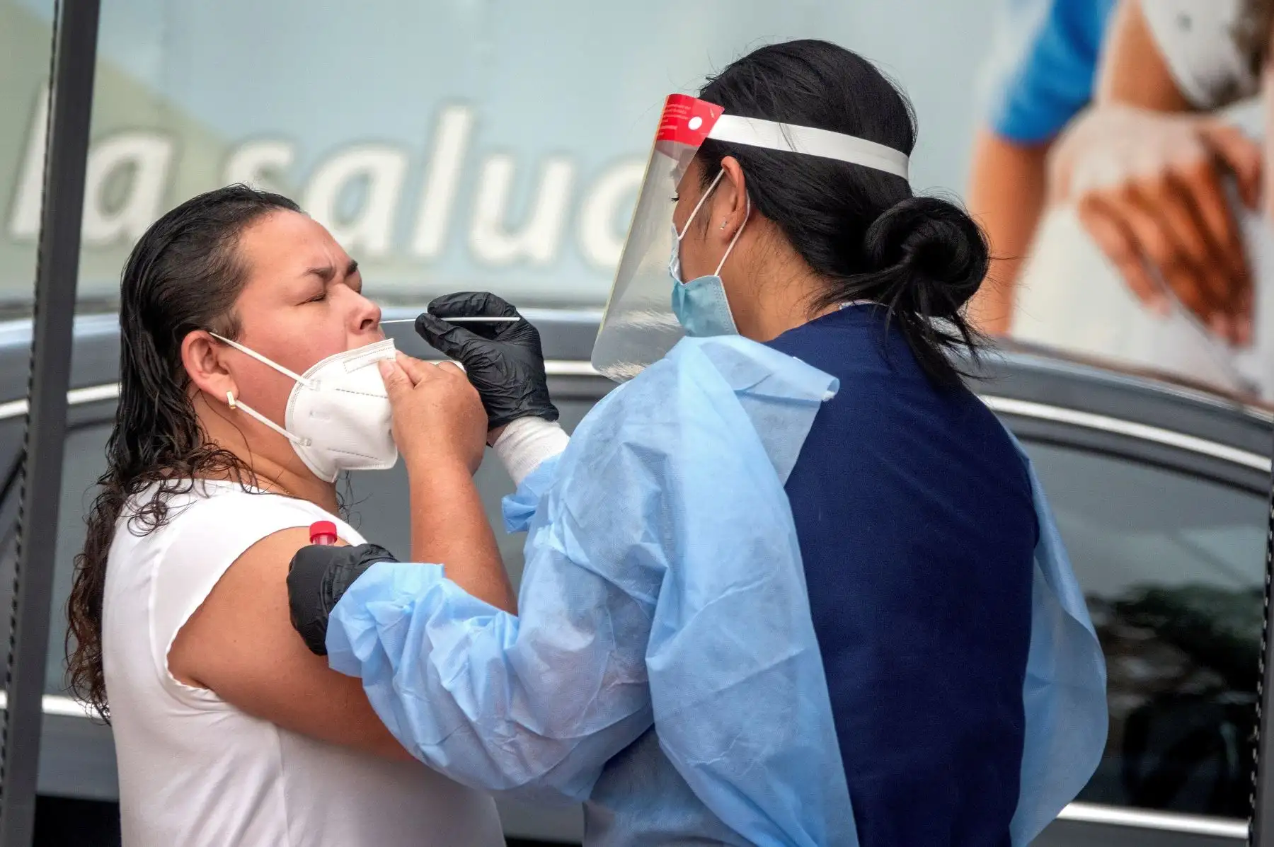Una mujer recibe su prueba de hisopo recolectada por un miembro del equipo de laboratorios LAB24 para detección de Covid-19, en el estacionamiento del Consulado de México en Miami, Florida. Foto: EFE
