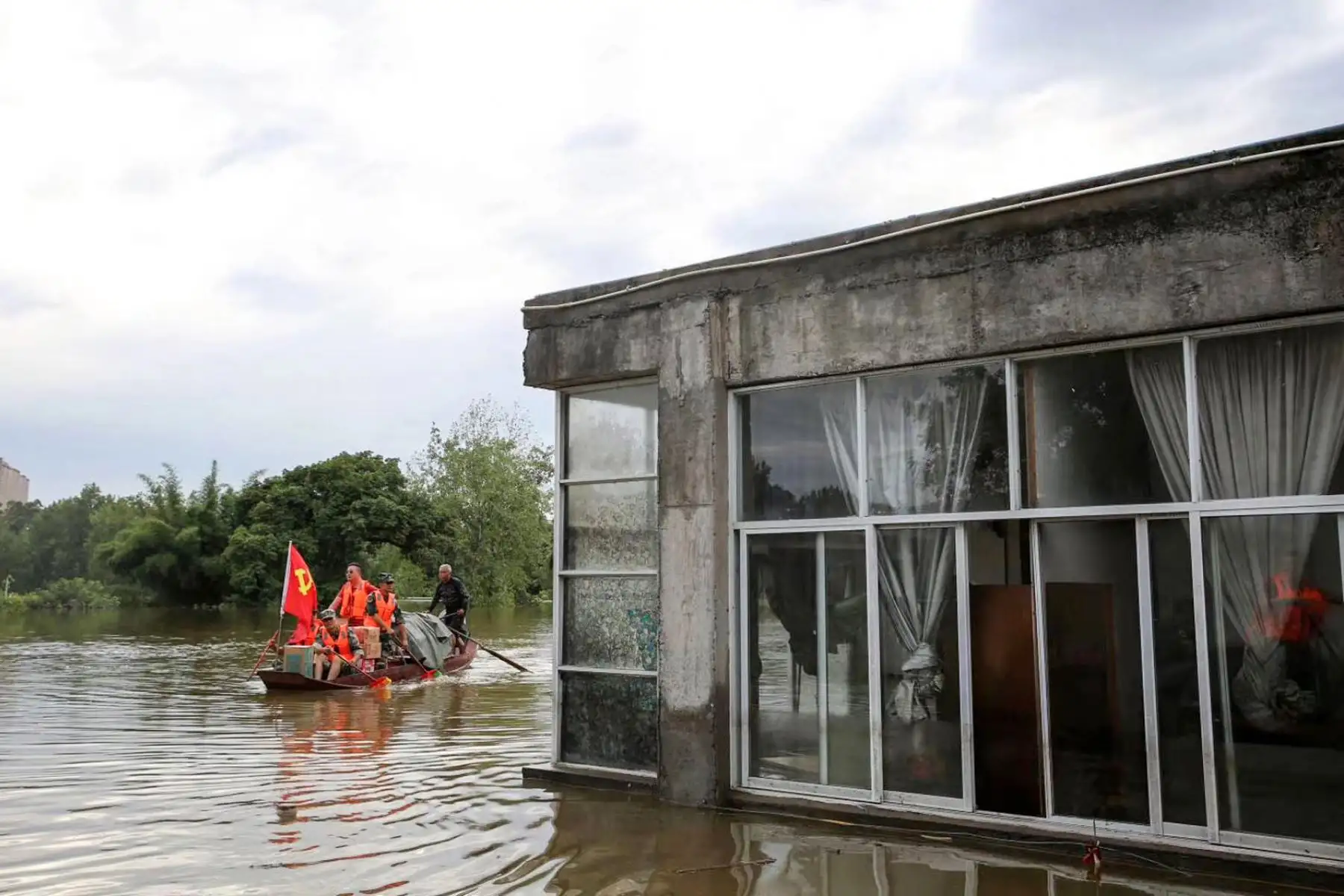 Trabajadores comunitarios y voluntarios entregan alimentos y suministros a los residentes afectados por las inundaciones después de las fuertes lluvias en Neijiang en la provincia de Sichuan, suroeste de China.

Foto: AFP