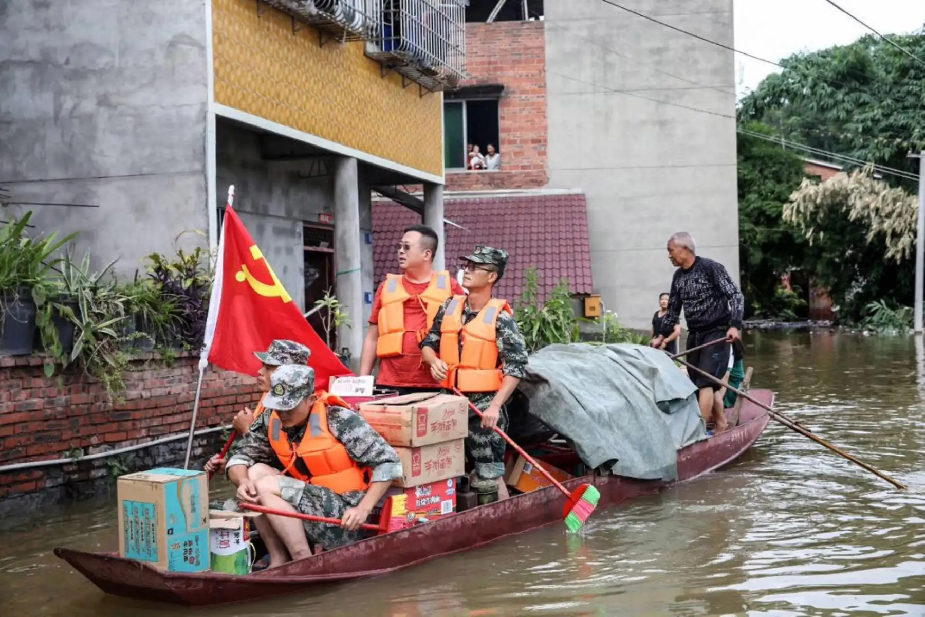 Trabajadores comunitarios y voluntarios entregan alimentos y suministros a los residentes afectados por las inundaciones después de las fuertes lluvias en Neijiang en la provincia de Sichuan, suroeste de China.

Foto: AFP