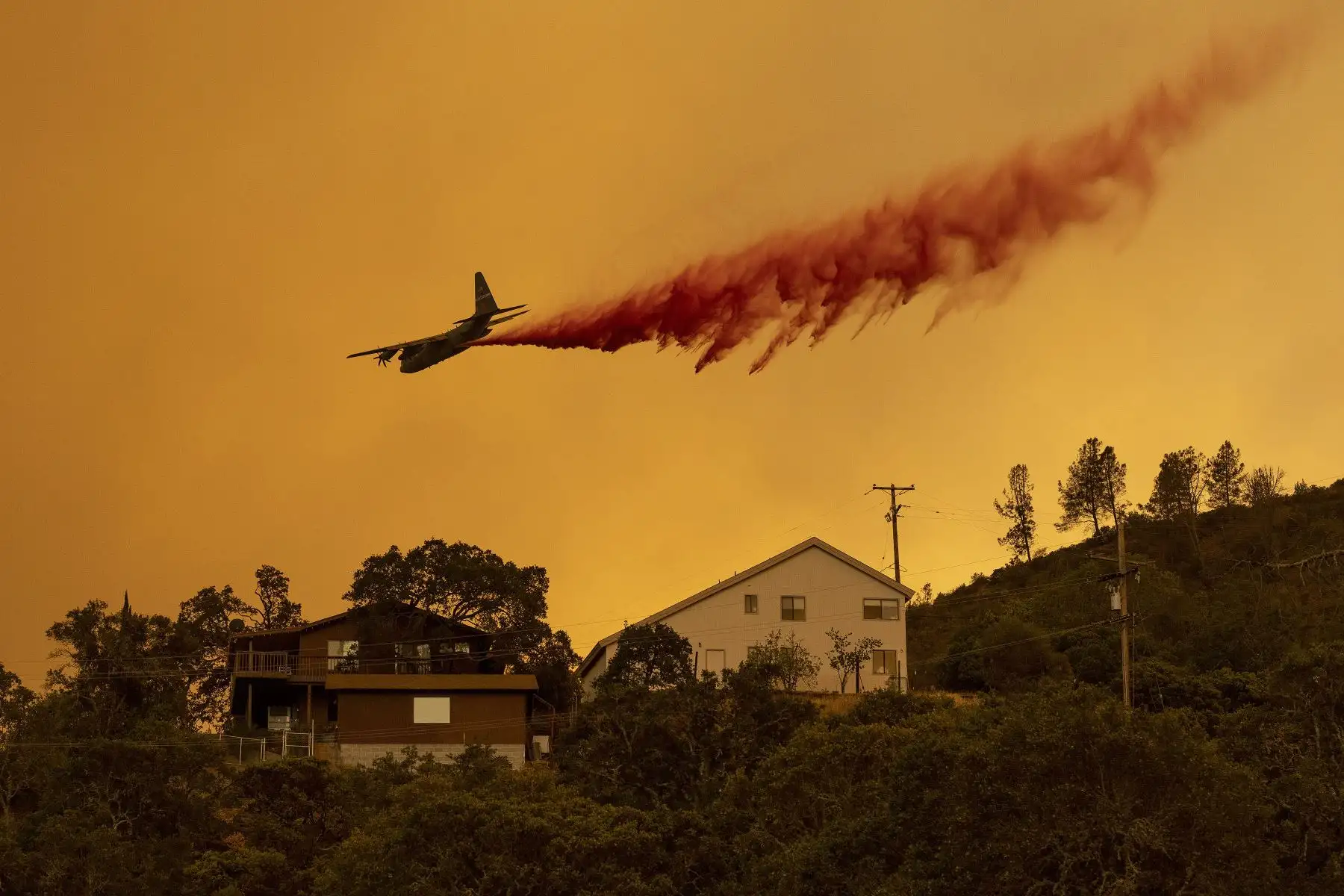 Un avión hace una caída retardante sobre viviendas en el área de Spanish Flat de Napa, California, durante el incendio de Hennessey.
Foto: AFP