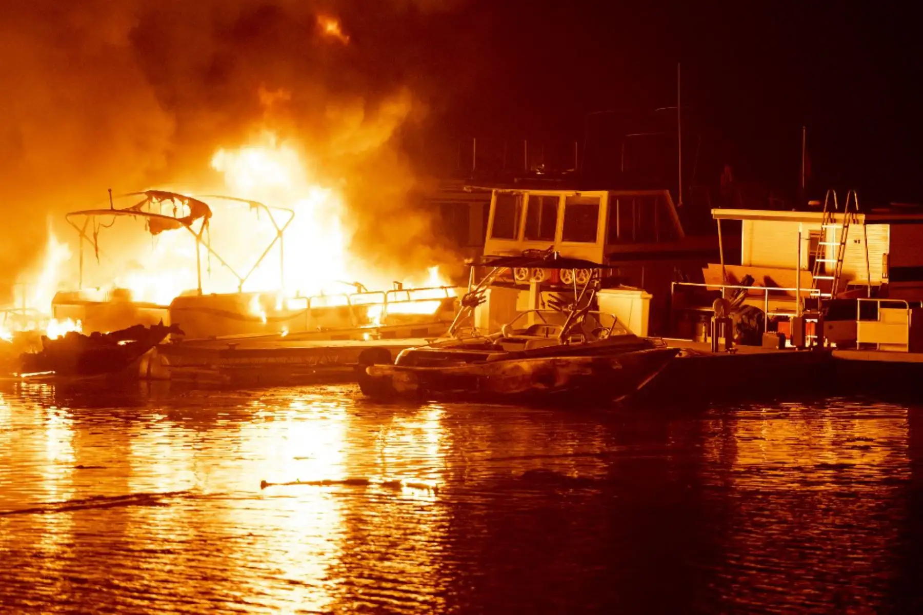 Barcos atracados se queman en el lago Berryessa durante el incendio del Complejo Relámpago LNU en Napa, California. Miles de personas huyeron de sus hogares en el norte de California cuando cientos de incendios forestales se extendieron rápidamente por la región, quemando casas y conduciendo a la muerte a un piloto de helicóptero. 

Foto: AFP