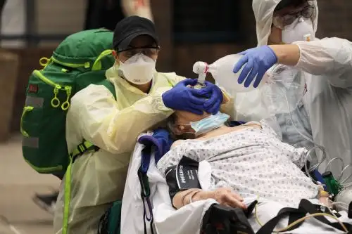 Médicos llevan a un paciente con dificultad respiratoria severa a una ambulancia desde un hogar grupal junto al Centro Médico Maimónides, en el vecindario de Borough Park del distrito de Brooklyn de la ciudad de Nueva York. Foto: AFP