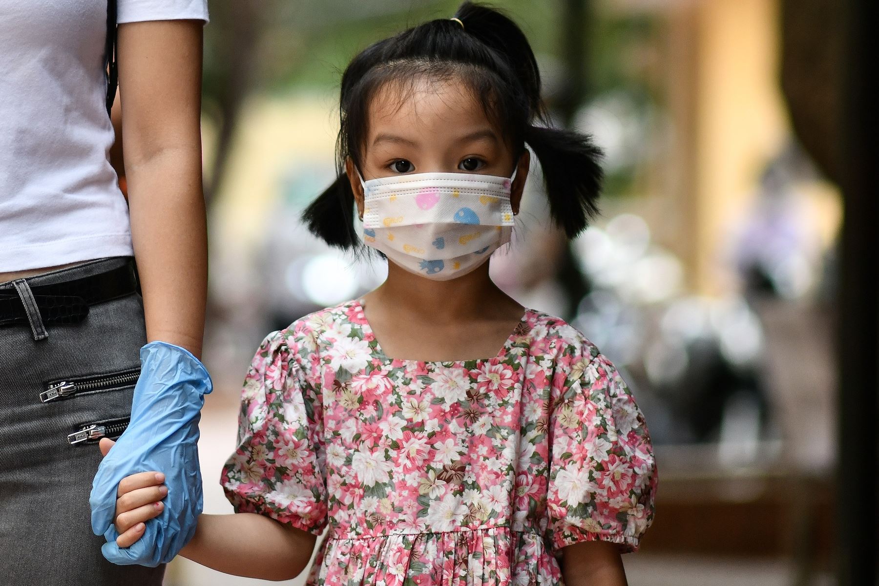 Una niña sostiene la mano de su madre a la espera de ser examinada en un centro de pruebas rápidas improvisado en Hanoi, mientras Vietnam registra un aumento en los casos del coronavirus covid-19. Foto: AFP.