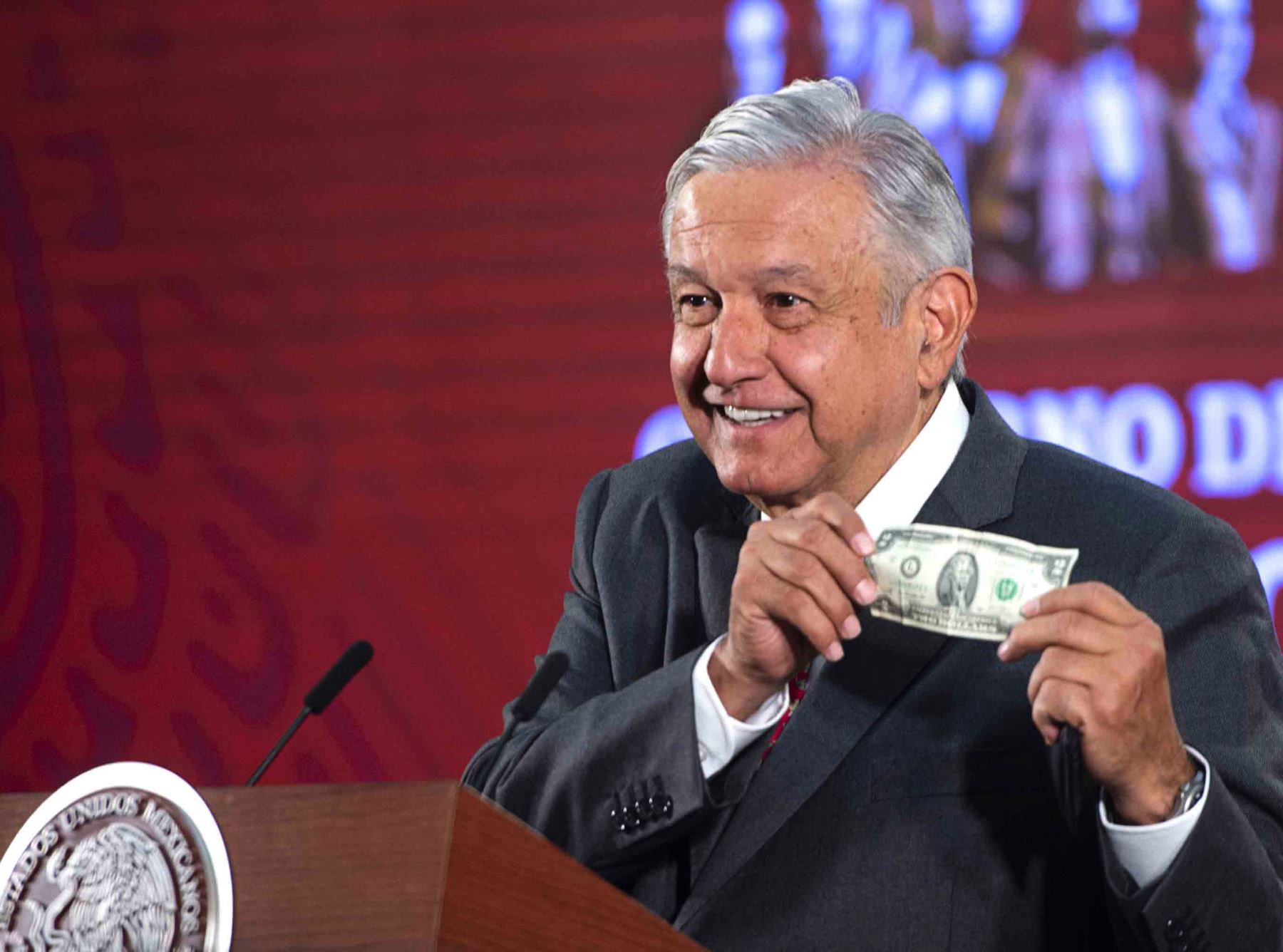 Imagen difundida por la Presidencia de México, muestra al presidente mexicano Andrés Manuel López Obrador mostrando un billete de dos dólares durante una conferencia de prensa en el Palacio Nacional en la Ciudad de México, el 18 de marzo de 2020. Foto: AFP