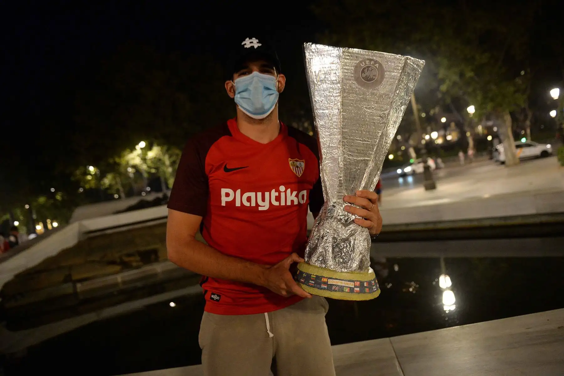 Un aficionado del Sevilla FC posa con una réplica del trofeo de la Europa League mientras celebra en las calles de Sevilla tras la victoria de su equipo en la final de la UEFA Europa League contra el Inter de Milán.
Foto: AFP