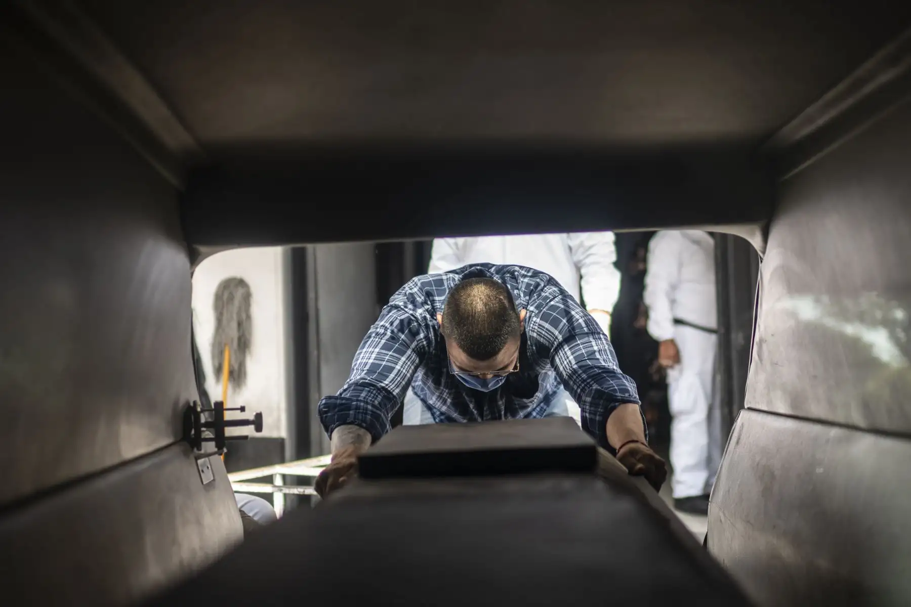 En esta foto de archivo tomada el 1 de junio de 2020, Mauricio Navarrete, de 27 años, descarga un ataúd con una víctima del covid-19 desde un coche fúnebre en un cementerio de la Ciudad de México. Foto: AFP