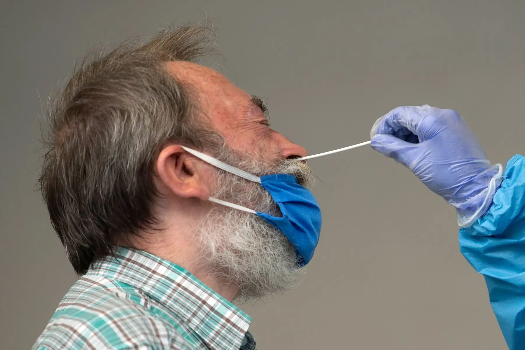 Un hombre reacciona cuando un trabajador de salud introduce un hisopo para detectar el coronavirus en su organismo, en la ciudad vasca española de Azpeitia. Foto: AFP
