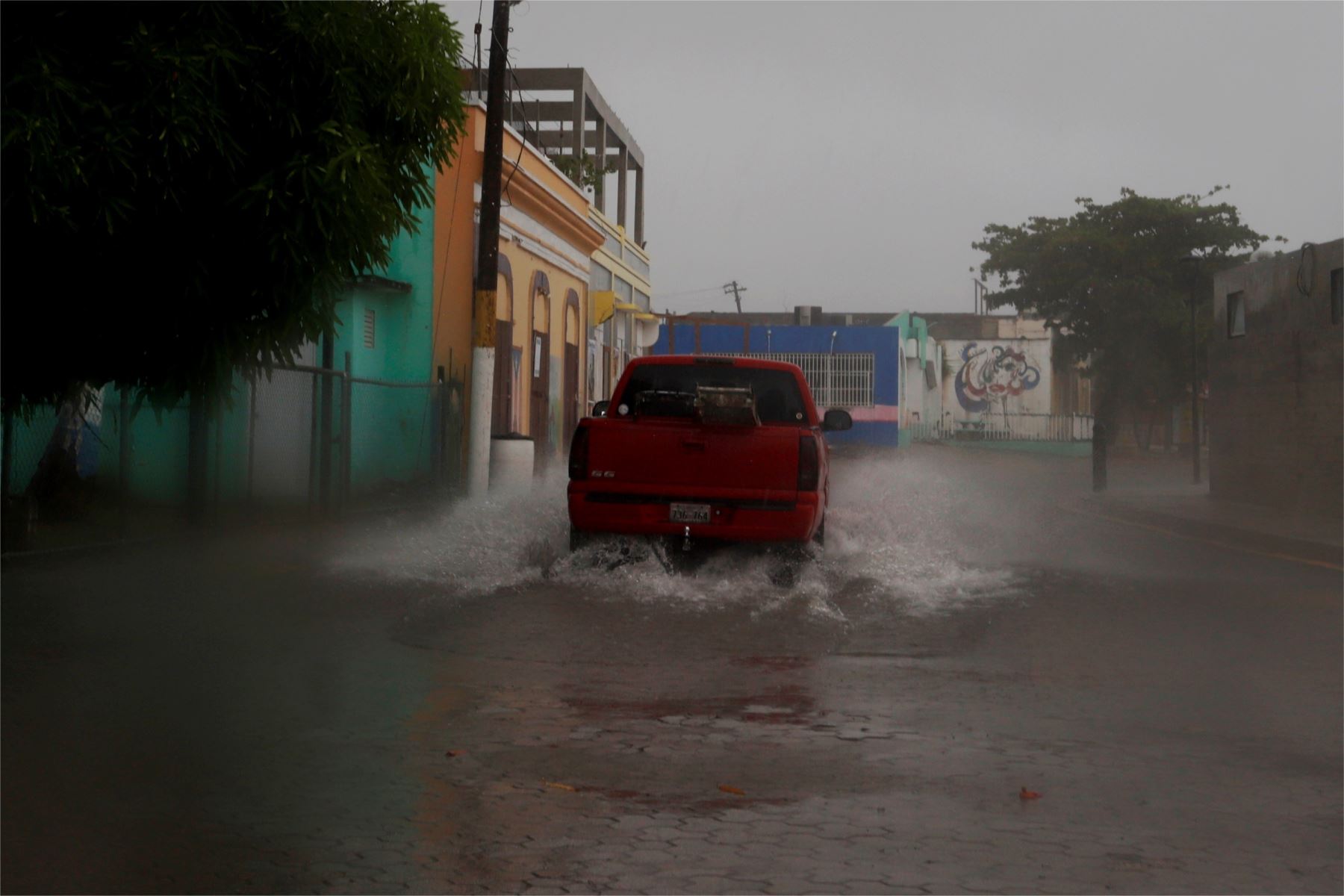 Una camioneta pasa por una calle inundada debido al paso de la tormenta Laura hoy. Foto: EFE