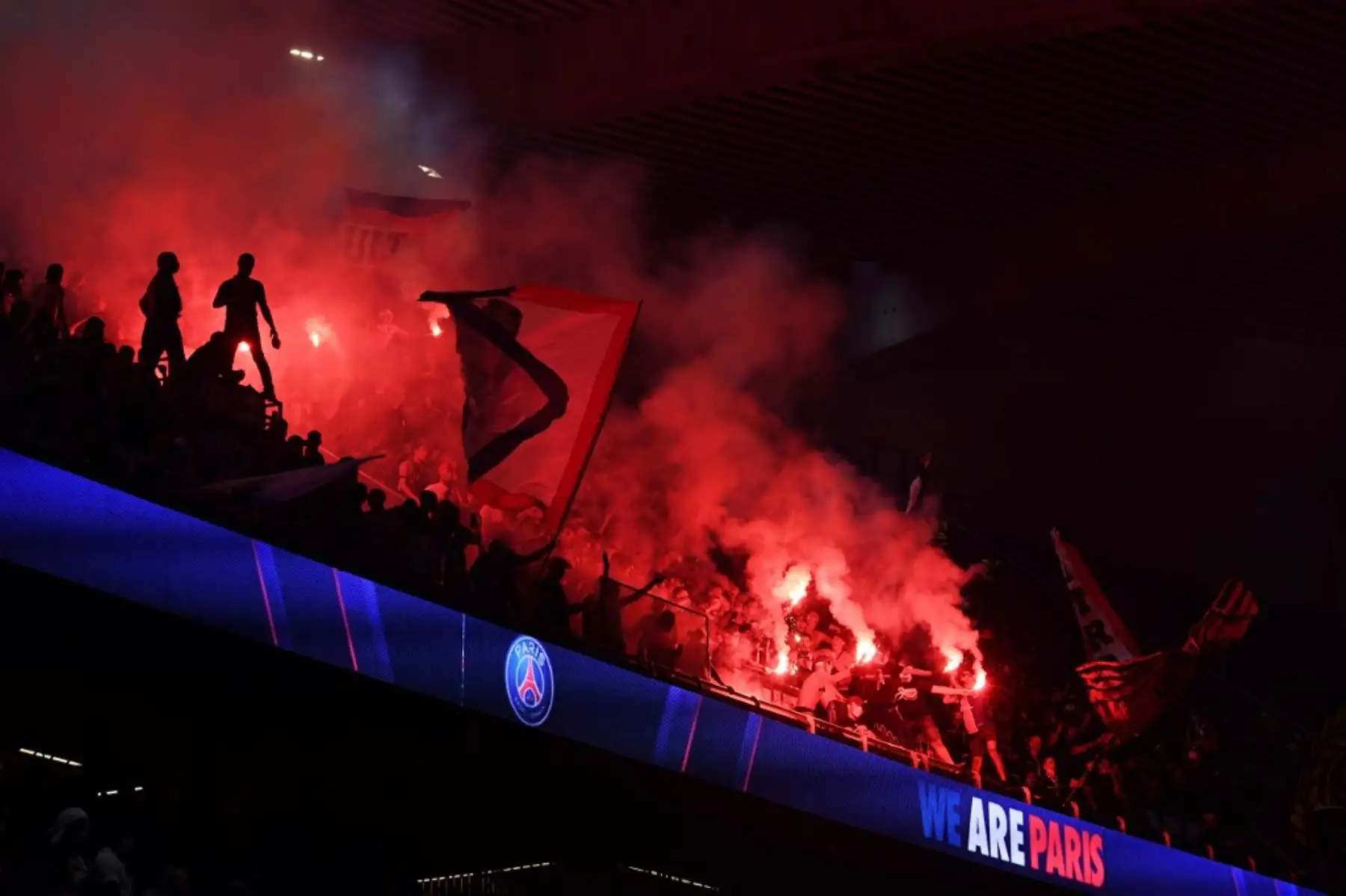 Los seguidores del Paris Saint-Germain (PSG) encienden bengalas y ondean banderas mientras miran en el Parc des Princes el 23 de agosto de 2020, el partido de fútbol final de la UEFA Champions League entre el PSG y el Bayern Munich jugado en el estadio Luz de Lisboa. Foto: AFP