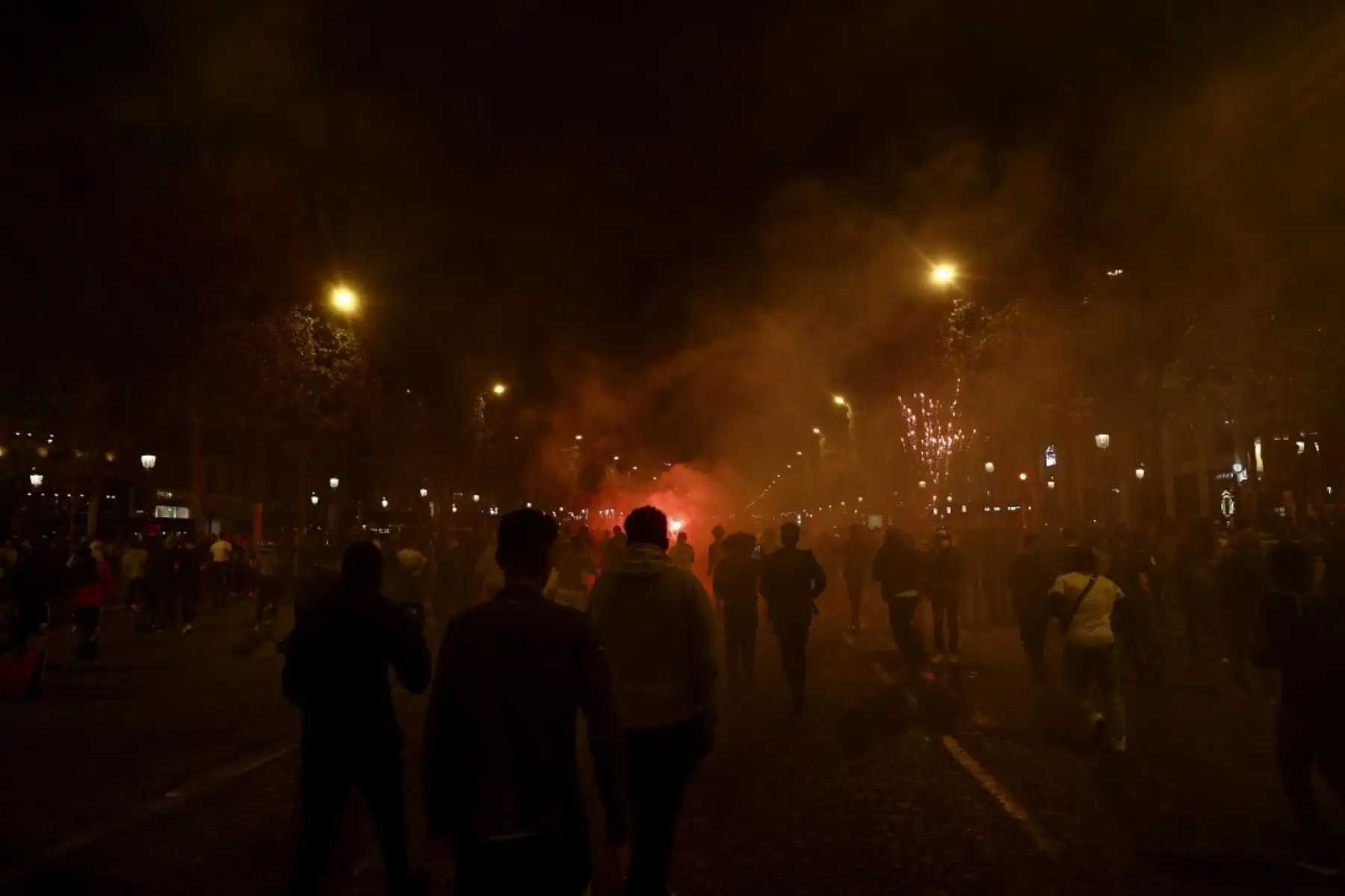 Los seguidores del Paris Saint-Germain (PSG) huyen de los botes de gas lacrimógeno en los Campos Elíseos en París el 23 de agosto de 2020, después del final del partido de fútbol final de la UEFA Champions League contra el Bayern de Múnich jugado en el estadio Luz de Lisboa. Foto: AFP