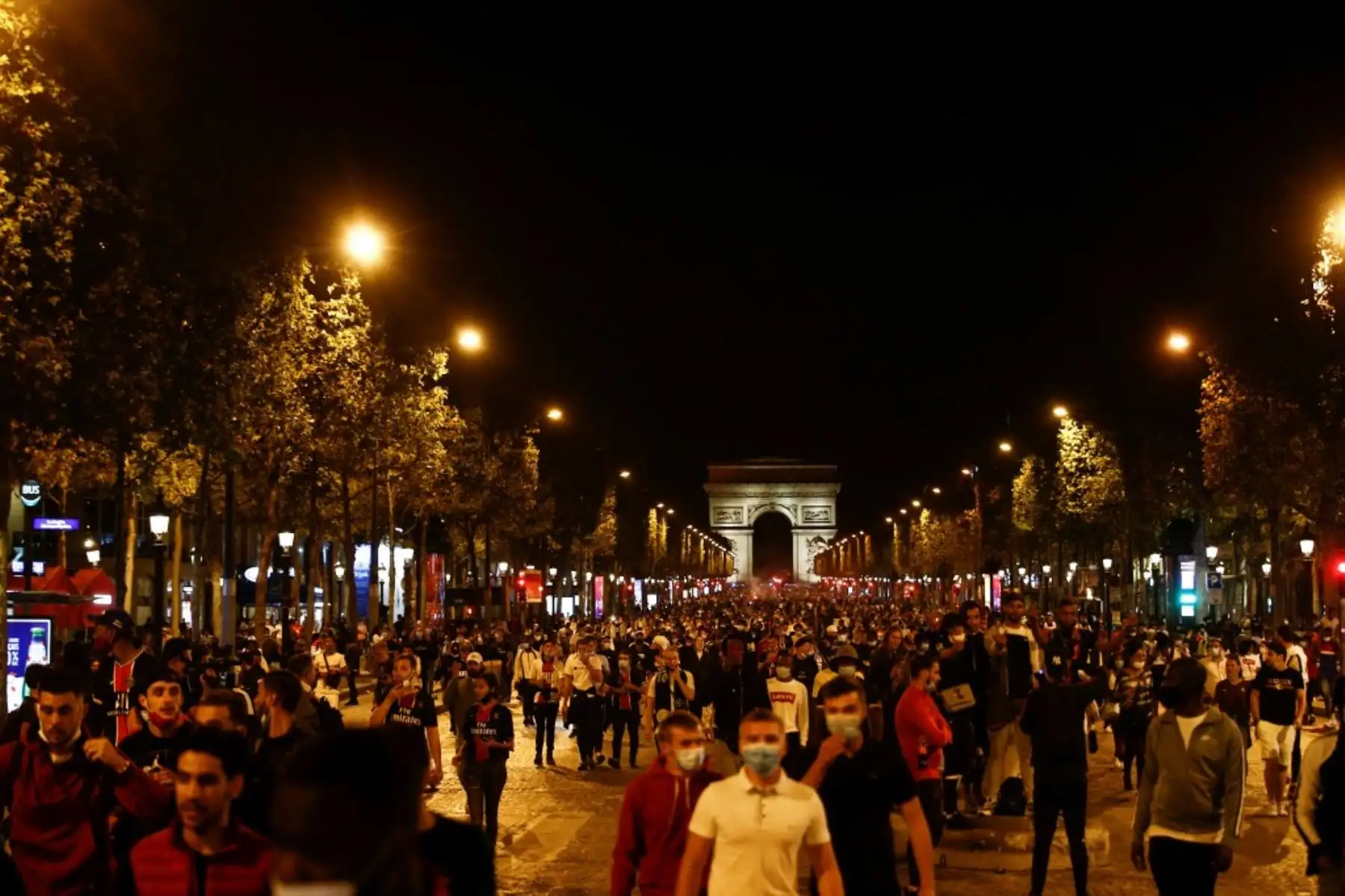 Los seguidores del Paris Saint-Germain (PSG) caminan por los Campos Elíseos en París el 23 de agosto de 2020, después del final del partido de fútbol final de la UEFA Champions League contra el Bayern de Múnich jugado en el estadio Luz de Lisboa. Foto: AFP